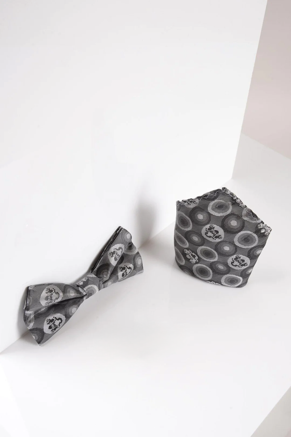 The Marc Darcy BUBBLES Grey Bubble Circle Print Bow Tie and Pocket Square Set adds subtle sophistication to any formalwear. Displayed on a white background, this set elevates your look with its stylish circular pattern.