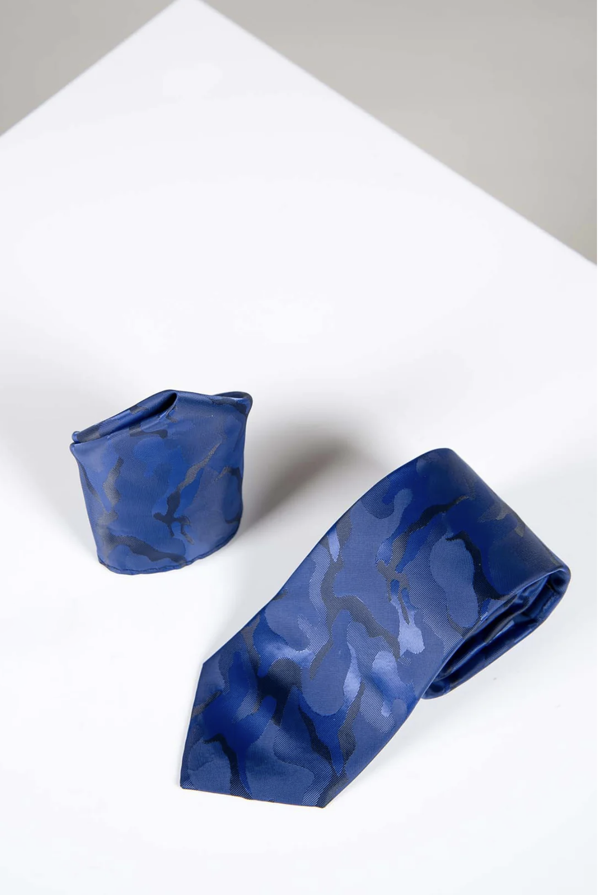 The TS ARMY - Navy Camouflage Tie and Pocket Square Set by Accessory features a stylish blue camo print tie and matching handmade pocket square, perfect for elevating your formalwear.