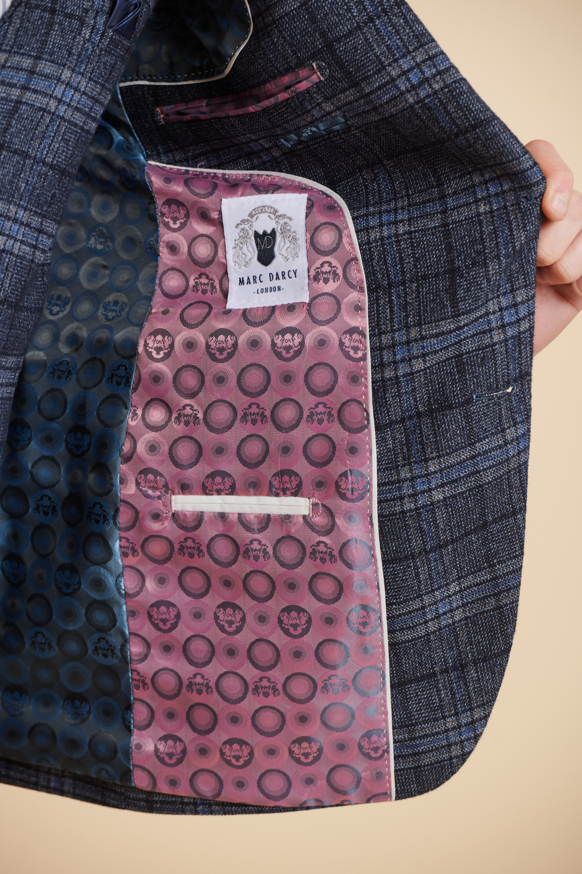 A close-up of the ANDY Blue Check Suit from The Everton Collection by Marc Darcy, featuring a pink inner pocket with a circular design and a white Marc Darcy label—a stylish detail highlighted by James Tarkowski.