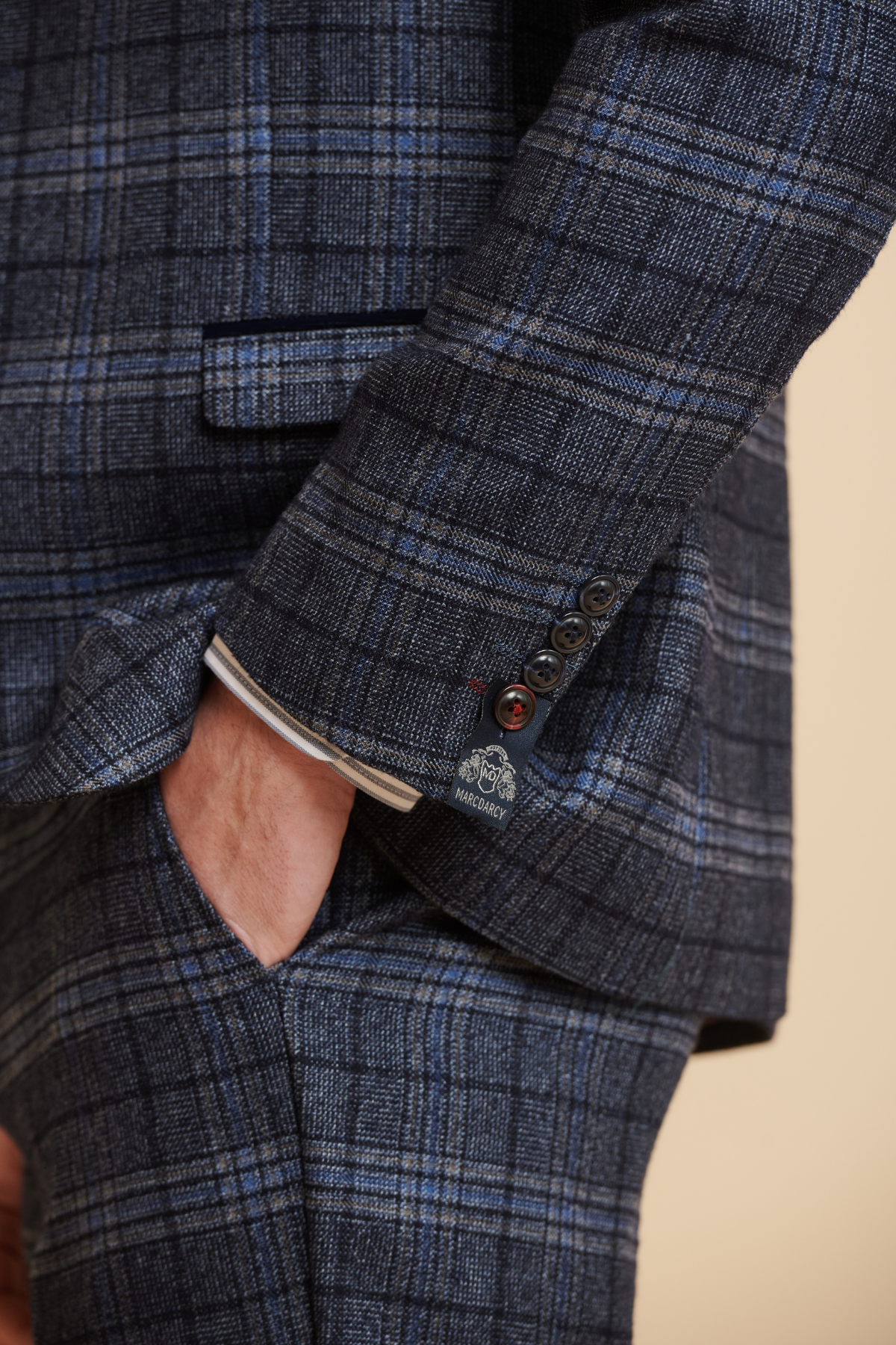 A close-up of a man in the Marc Darcy ANDY Blue Check Three Piece Suit, hand in pocket, showcasing the slim fit jacket's detailed design and button cuffs.