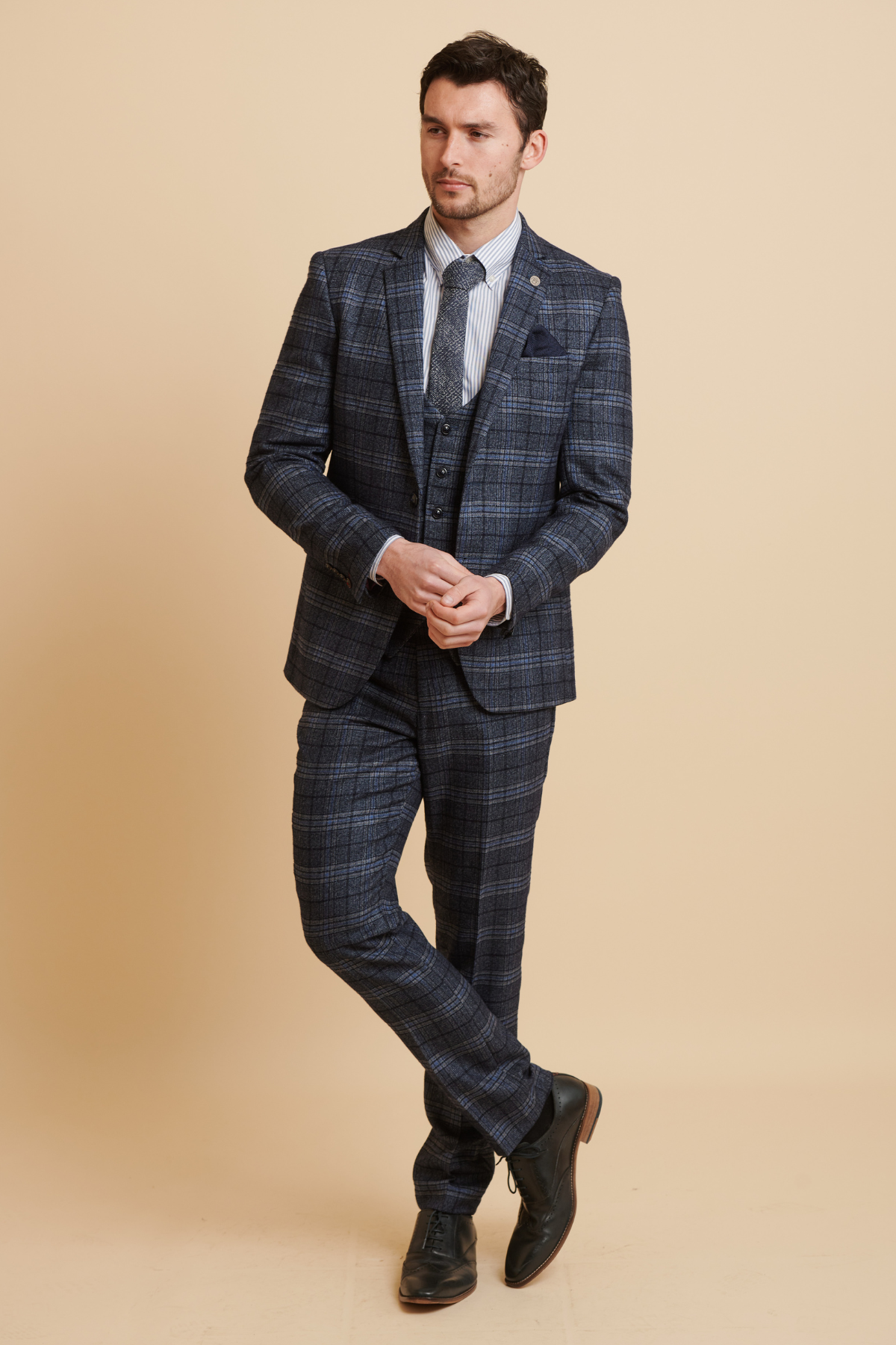 James Tarkowski wears the Marc Darcy Everton Collection's ANDY Blue Check Suit—a sharp three-piece paired with a striped shirt, patterned tie, pocket square, and black dress shoes—perfect for men’s formalwear.