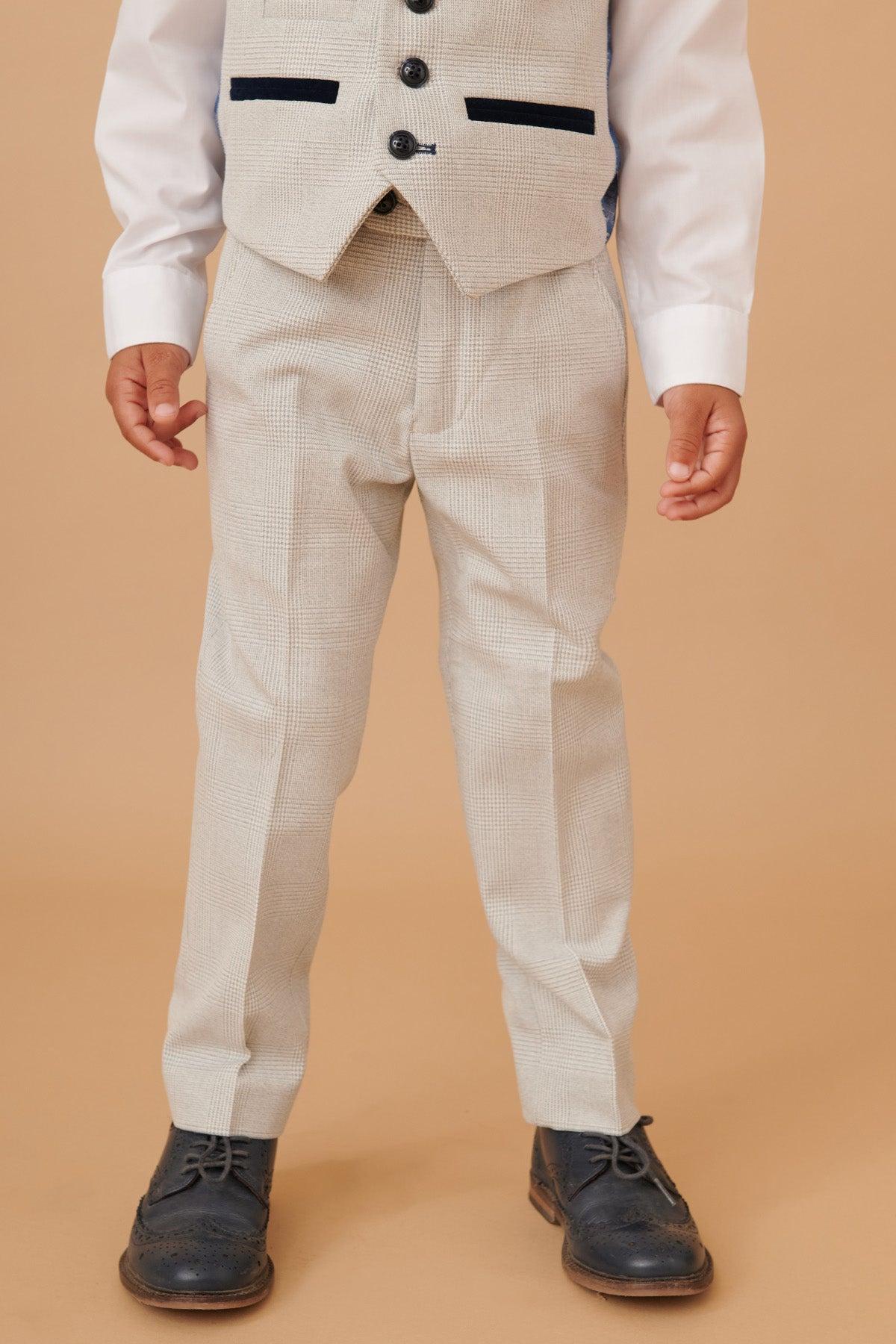 A child wears the Marc Darcy BROMLEY Children's Stone Check Print Three Piece Suit with a white shirt and dark blue dress shoes, mirroring the classic style of its adult counterpart.