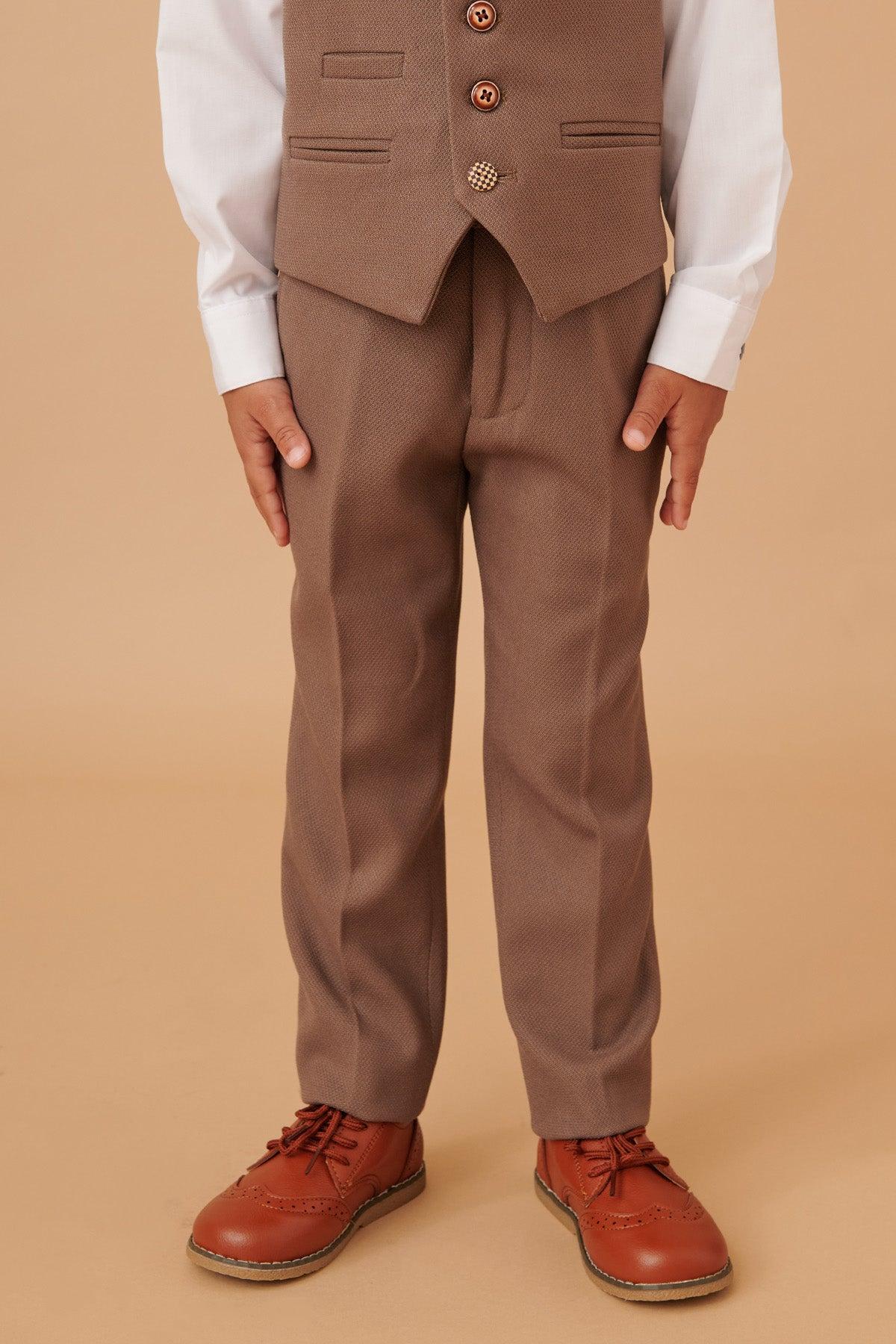 A child wears the Marc Darcy HM5 – Children’s Tan Tailored Three Piece Suit, complete with matching pants and white shirt—ideal for weddings or any special occasion.