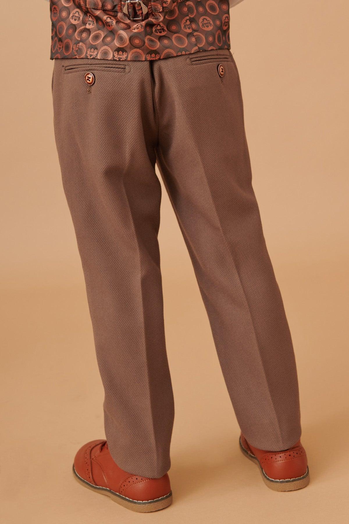 A child models the HM5 - Children's Tan Tailored Three Piece Suit by Marc Darcy, featuring classic dress pants and a coordinated jacket, set against a solid beige background for a refined formal look.