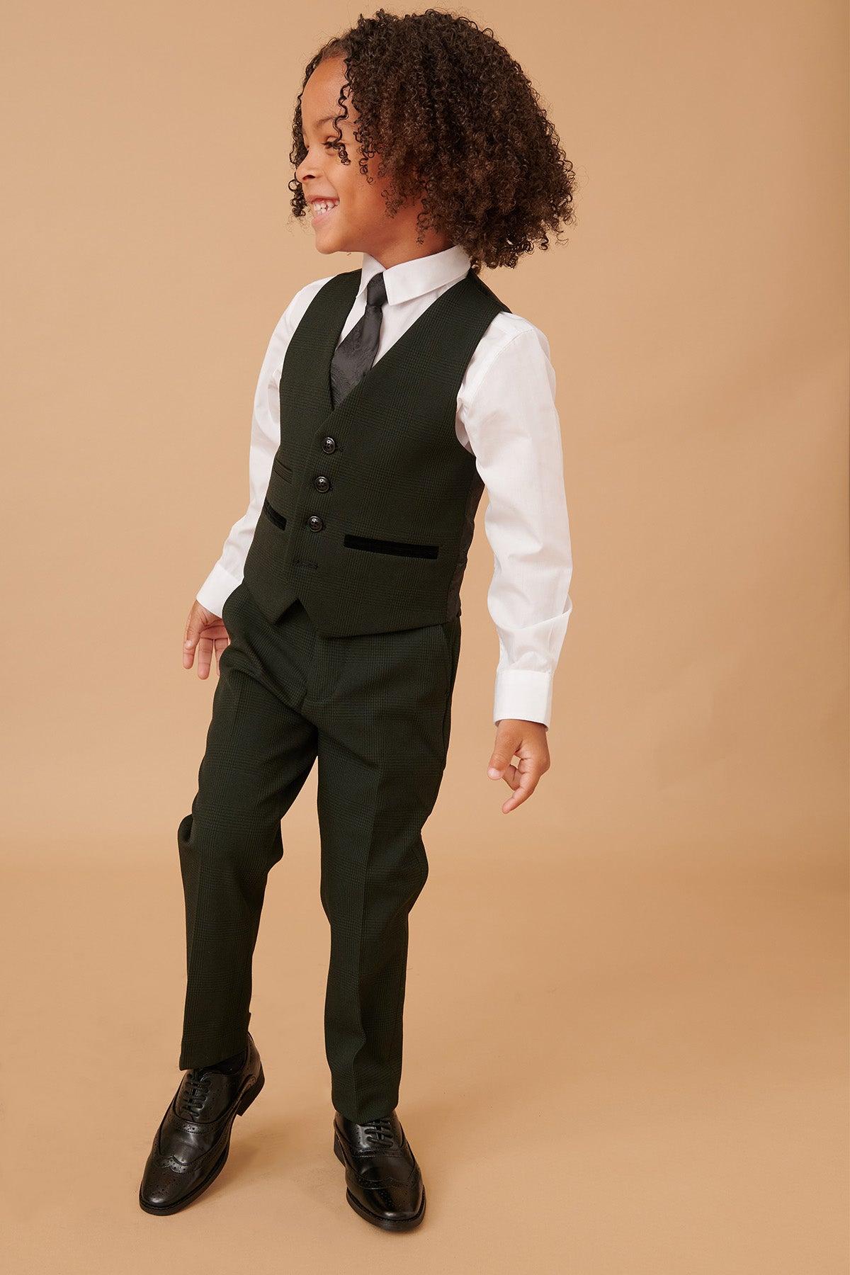 A young child with curly hair smiles against a beige background, wearing the Marc Darcy BROMLEY Children's Olive Green Check Print Three Piece Suit.
