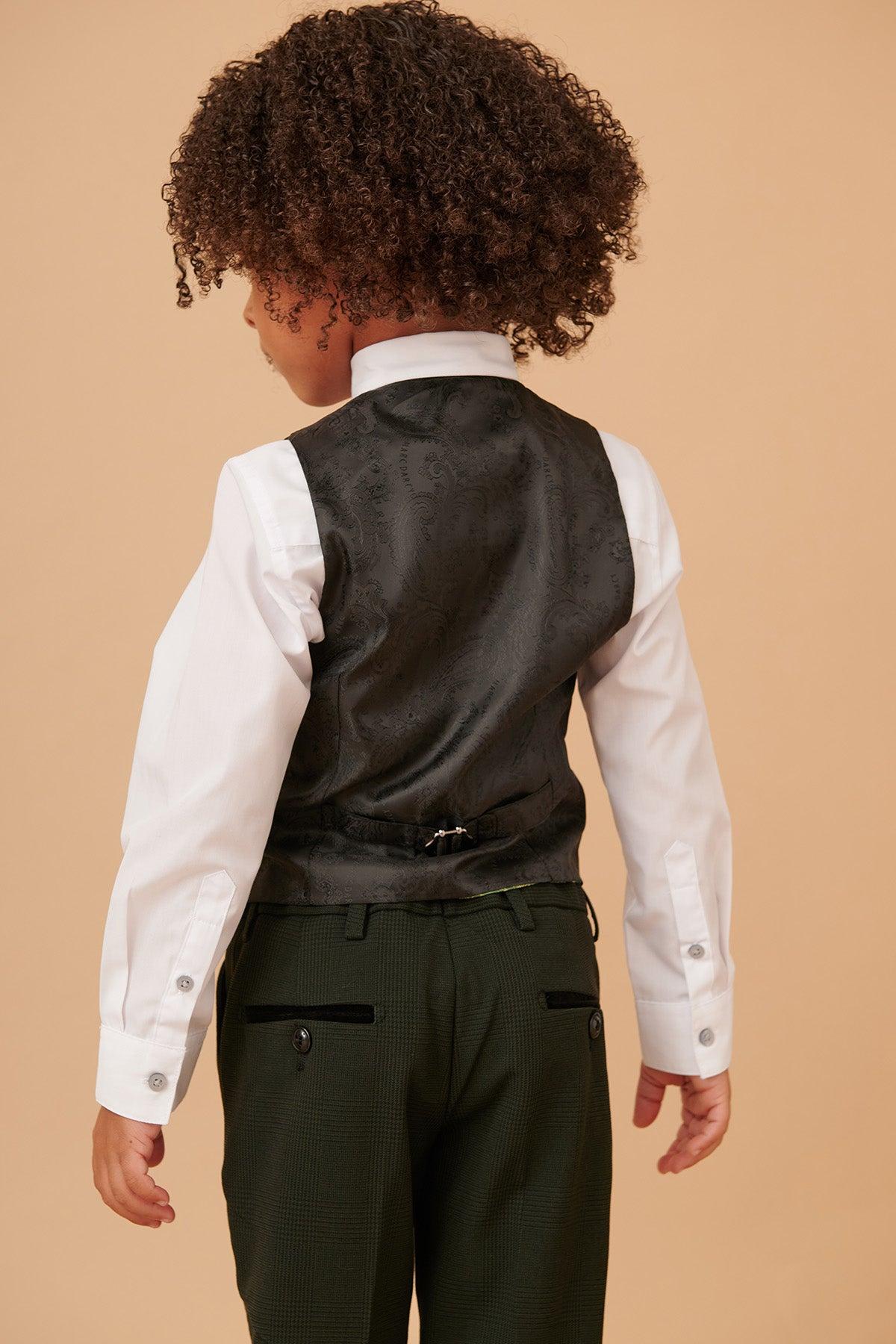 A young child with curly hair, seen from behind, models the Marc Darcy BROMLEY Childrens Olive Green Check Print Three Piece Suit against a beige background.