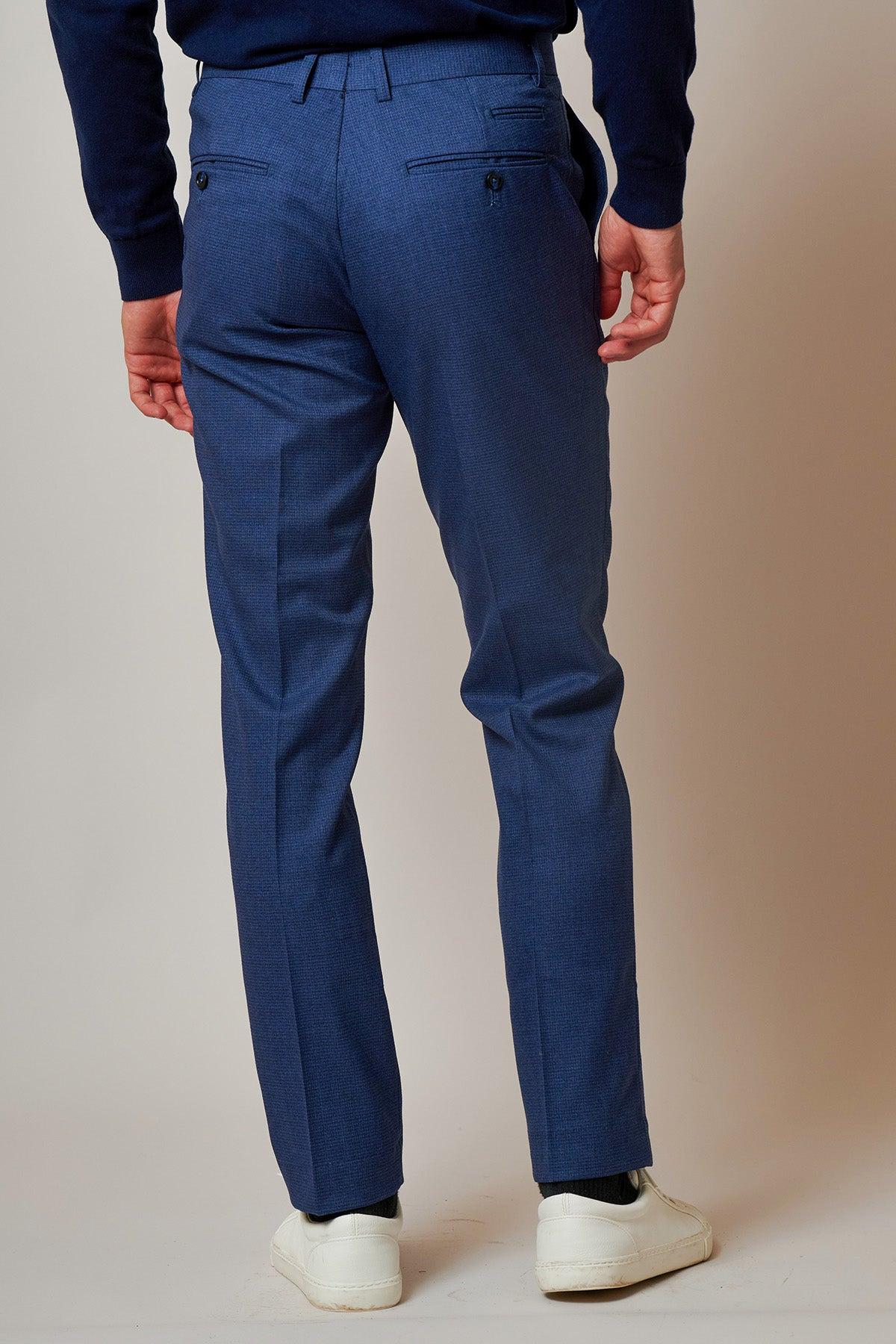 A person is shown from the back wearing the ASHLEY Navy Blue Two Piece Suit by Marc Darcy, paired with a dark sweater and white sneakers, standing against a neutral background.