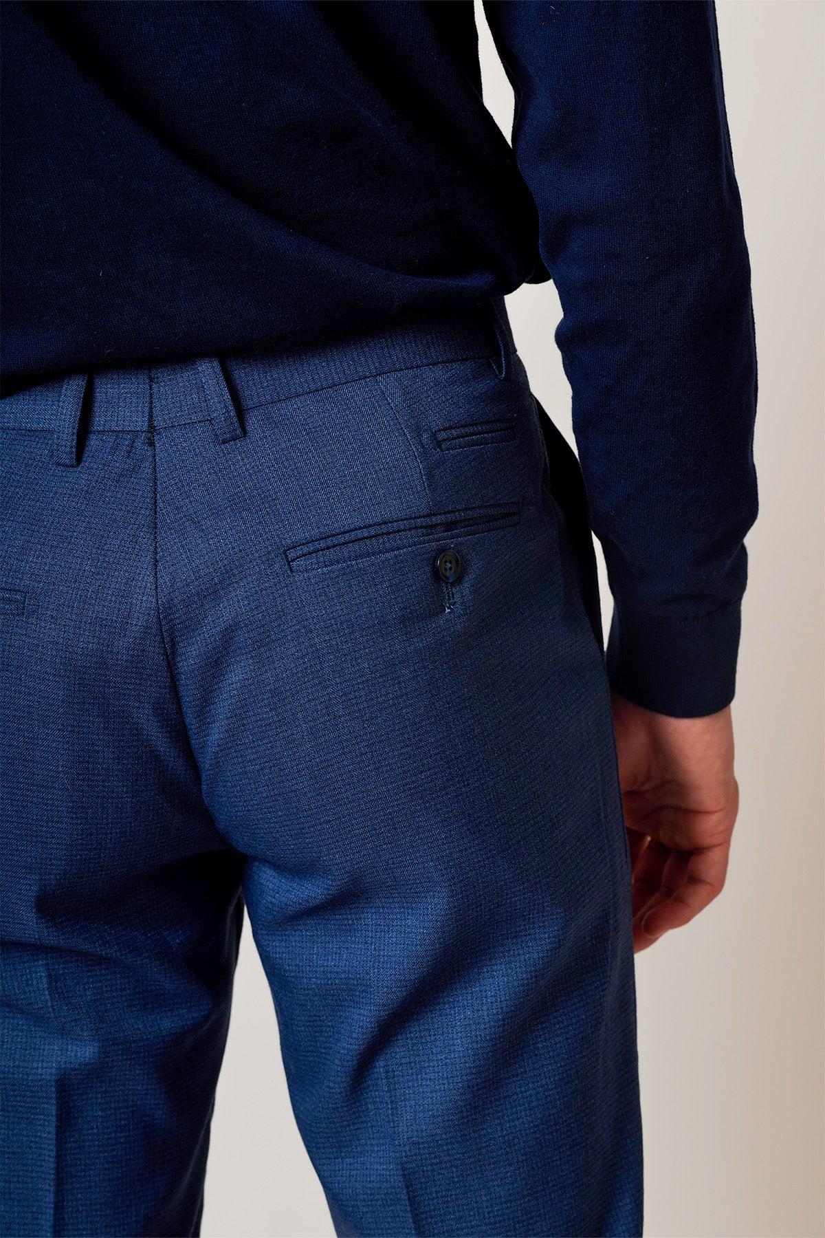 A person is shown from the waist down wearing the Marc Darcy ASHLEY - Navy Blue Two Piece Suit, featuring back pockets and a button detail, with their right arm relaxed by their side.