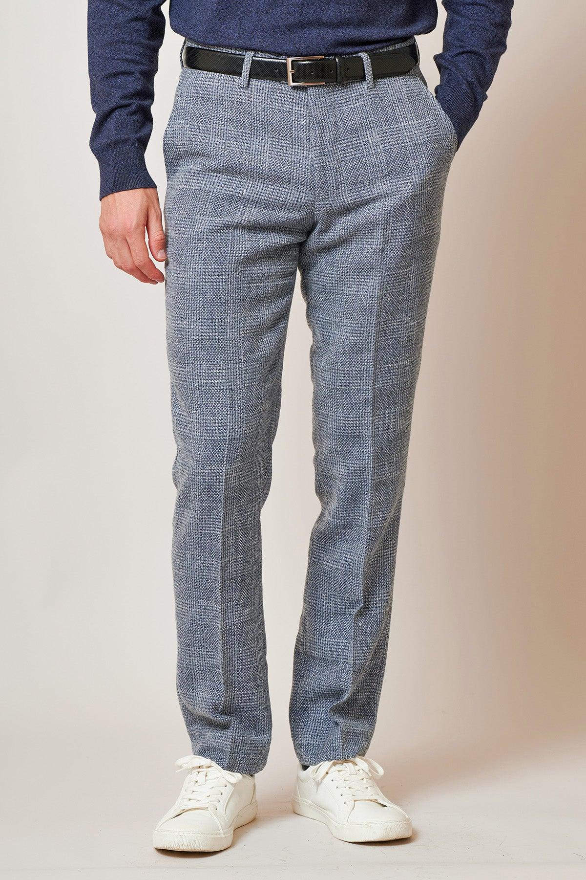 Dressed in The Everton Collection | Tim Iroegbunam In KRIS Sky Blue Tweed Suit by marcdarcy, a person stands with hands in their pockets against a plain background.