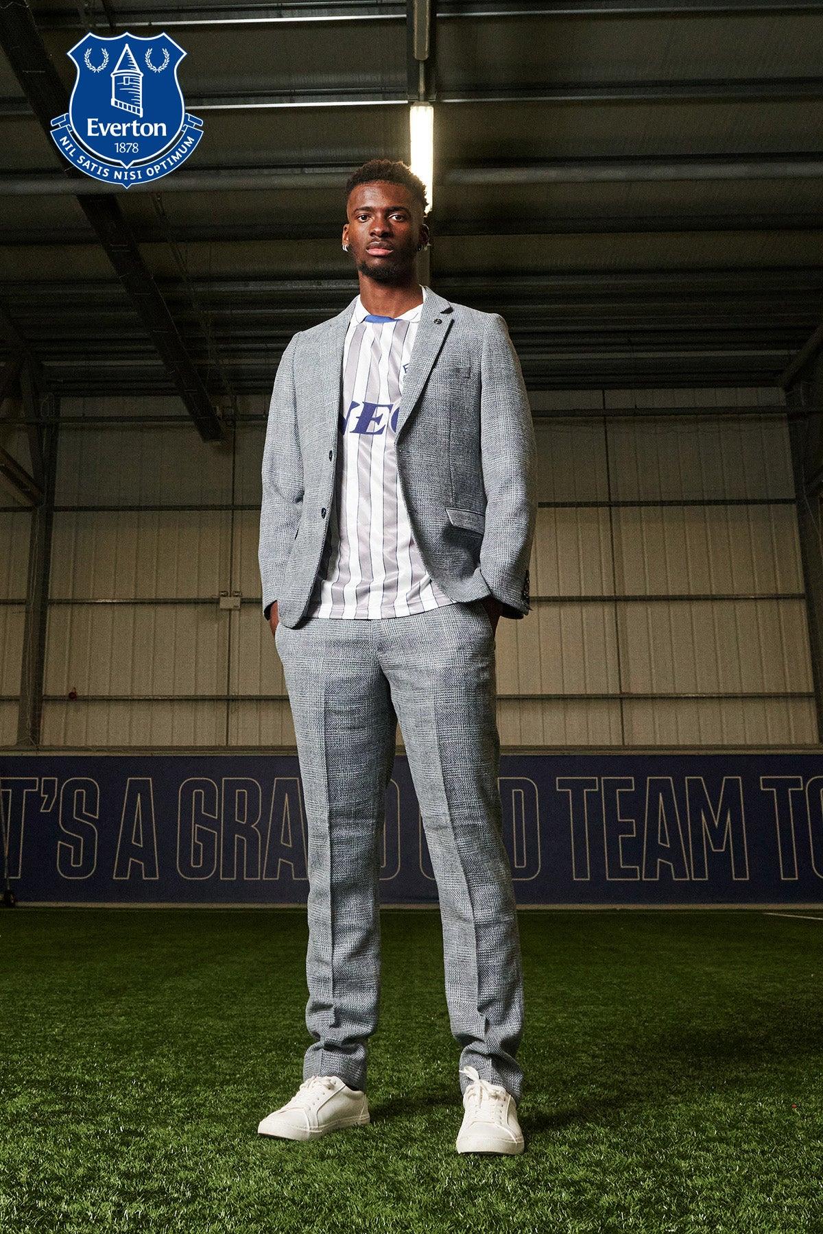Tim Iroegbunam of Everton models marcdarcy’s The Everton Collection in the KRIS Sky Blue Tweed Suit, styled with hands in his pockets.
