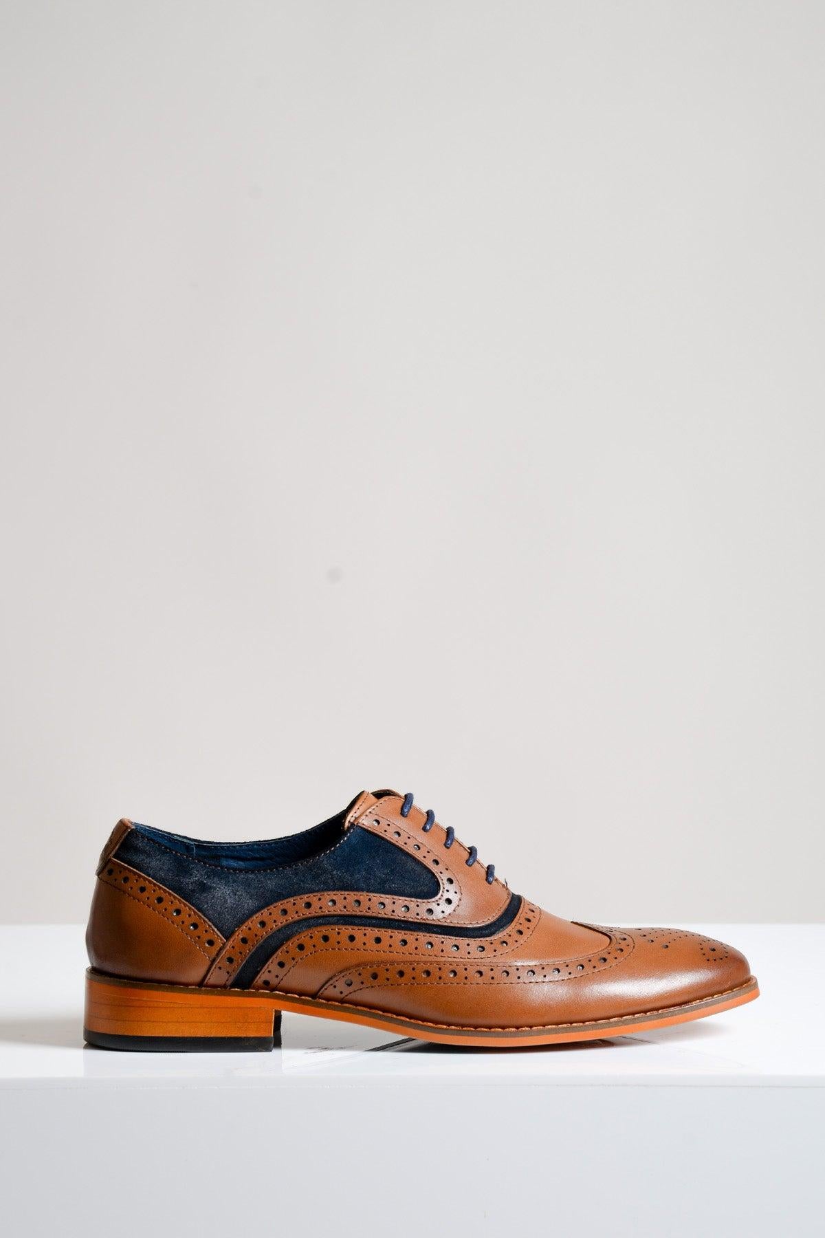 The Marc Darcy MURRAY - Contrast Tan Leather Suede Brogue Shoe features hand-stitched detailing, navy suede accents, decorative perforations, and a wooden heel, displayed on a white surface with a light gray background.