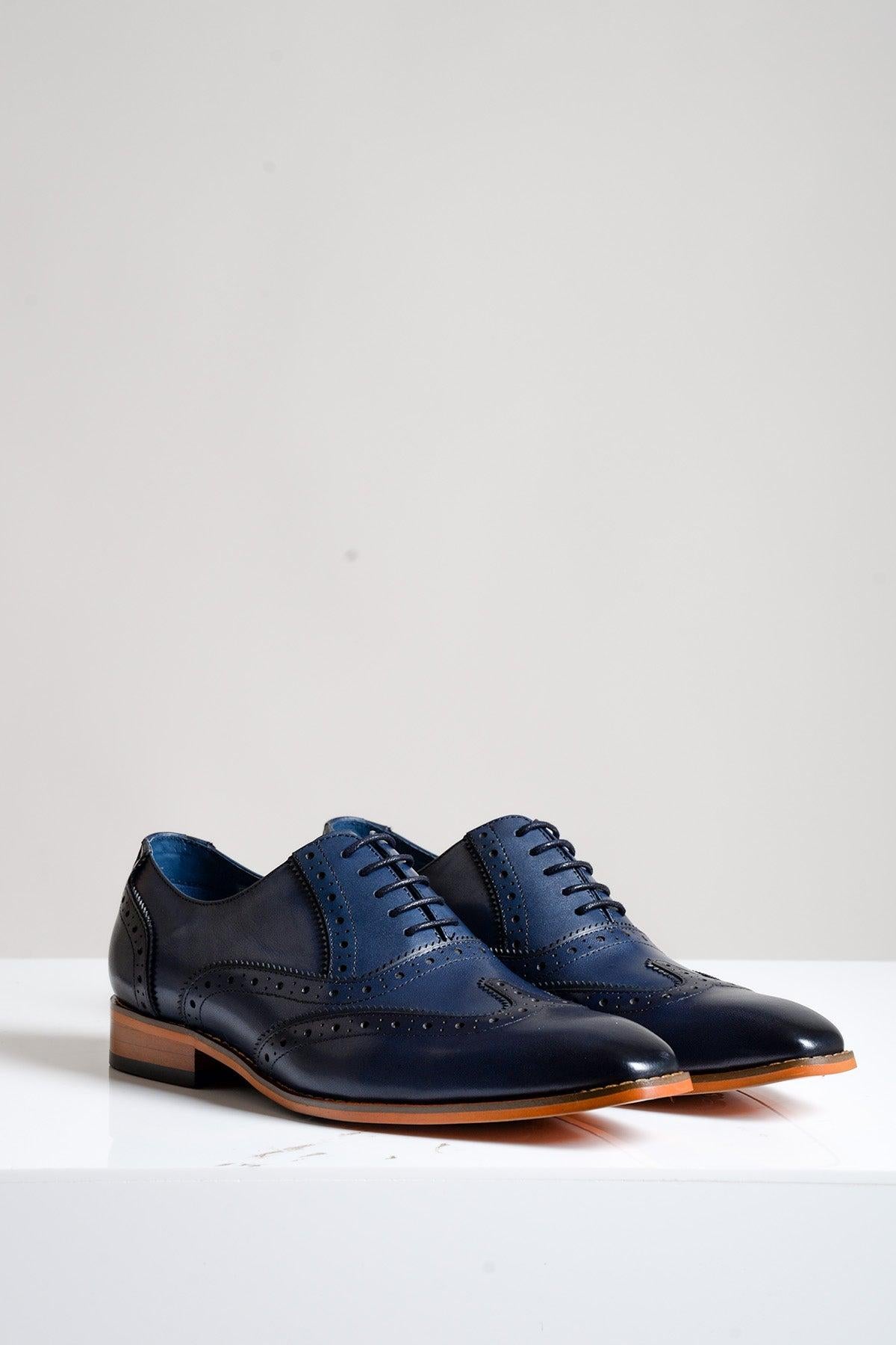 The MARCO Navy Blue Leather Oxford Wingtip Shoe by Marc Darcy features full grain leather, brown soles, and hand-stitched details. Displayed on a white surface with a plain light gray background.