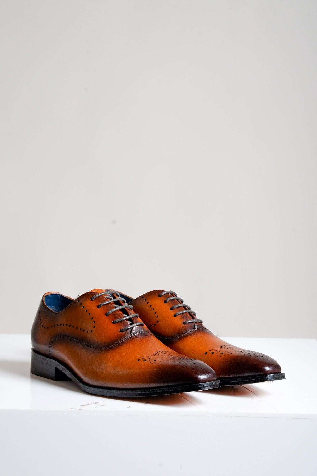The Marc Darcy JAKE - Tan Leather Contrast Oxford Shoe features decorative perforations, black soles, and laces—ideal for business wear. Displayed on a white surface against a plain light background.