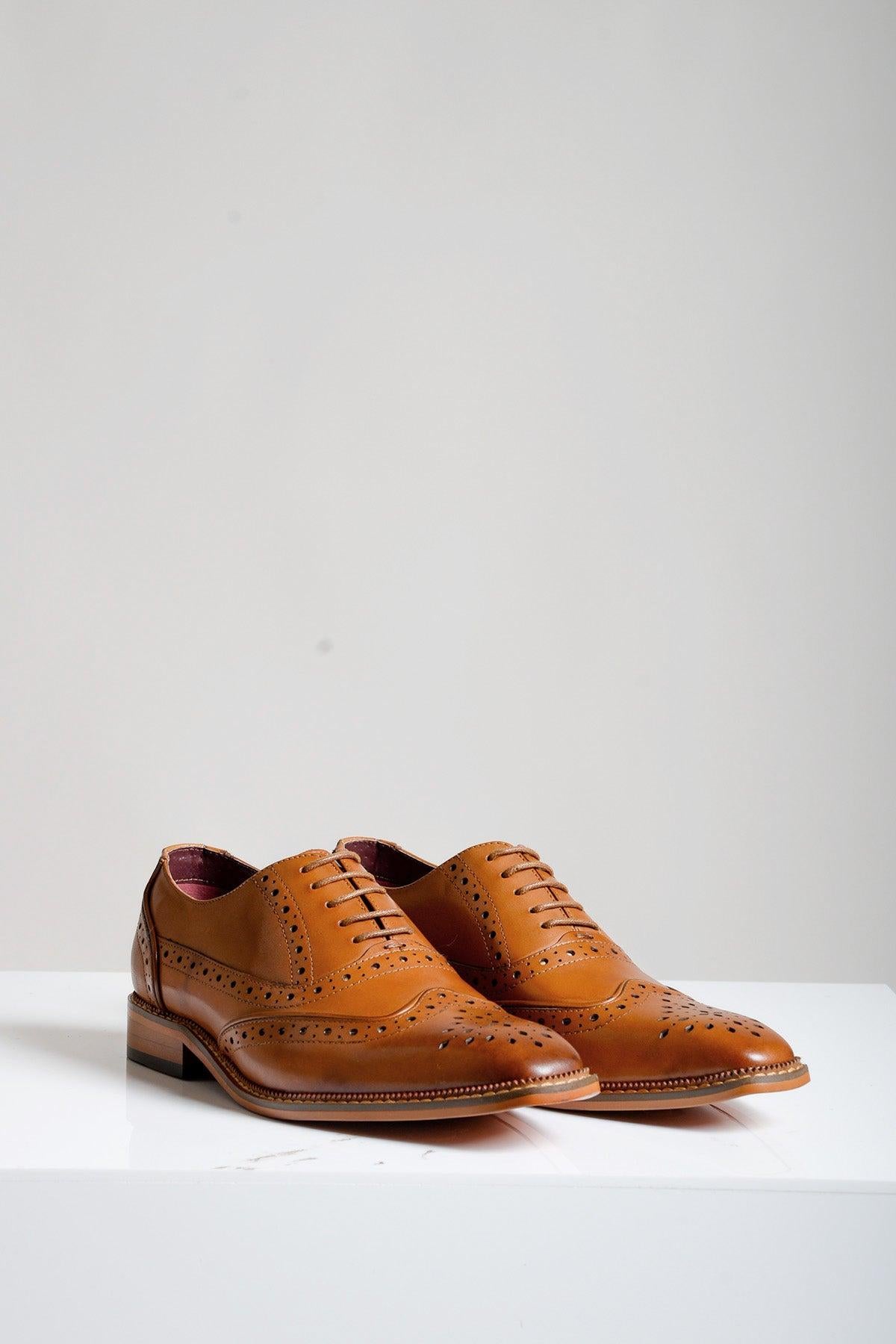 The Marc Darcy LARKIN Tan Leather Brogue Shoe features decorative perforations, laces, and wooden soles, displayed on a white surface against a plain light background.
