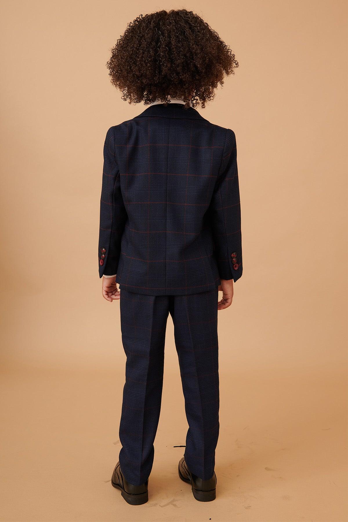 Back view of a child with curly dark hair in the Marc Darcy EDINSON Children's Navy Wine Check Print Three Piece Suit, paired with black dress shoes—perfect for coordinating with matching father and son outfits.