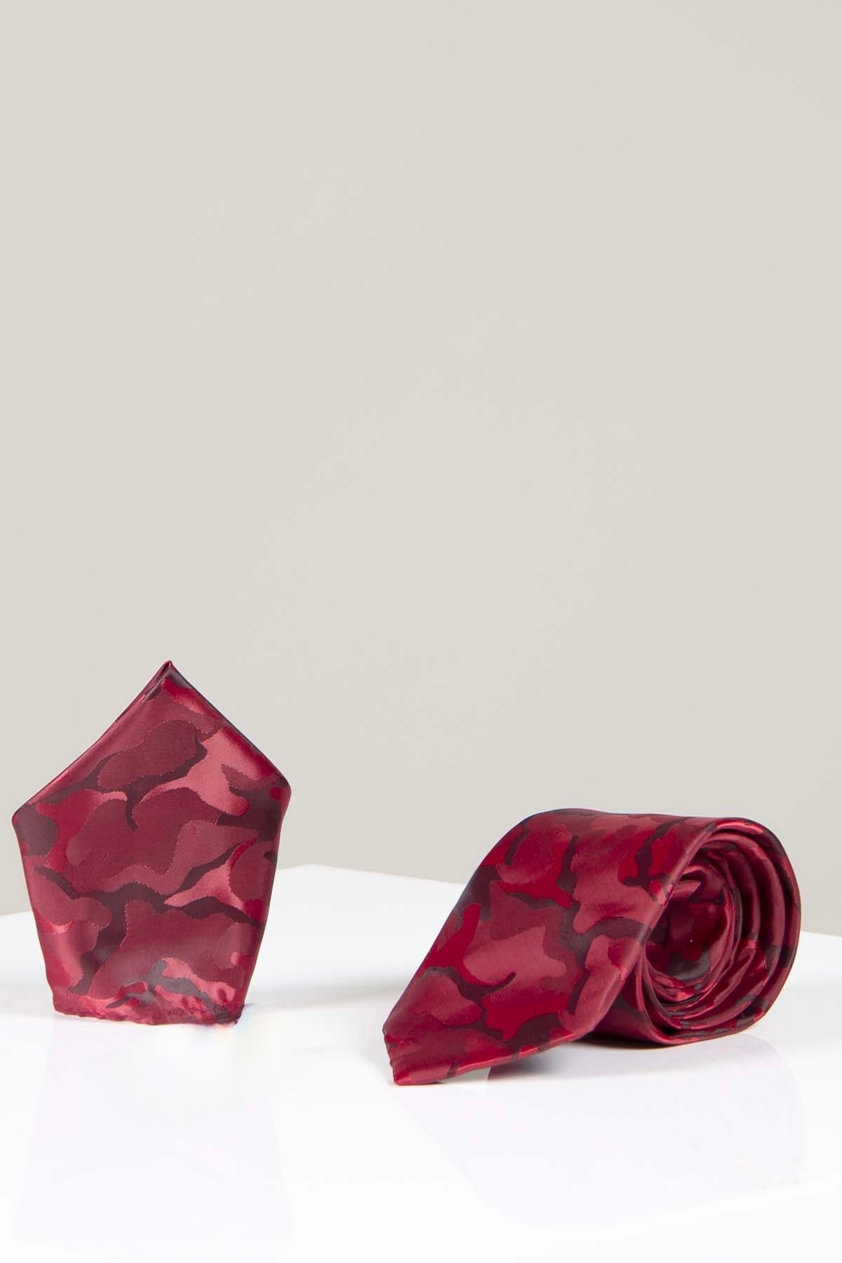 The TS ARMY - Wine Camouflage Tie and Pocket Square Set by Accessory features a bold red and pink pattern, rolled up with a matching handmade pocket square on a white surface, ideal for standout formalwear.
