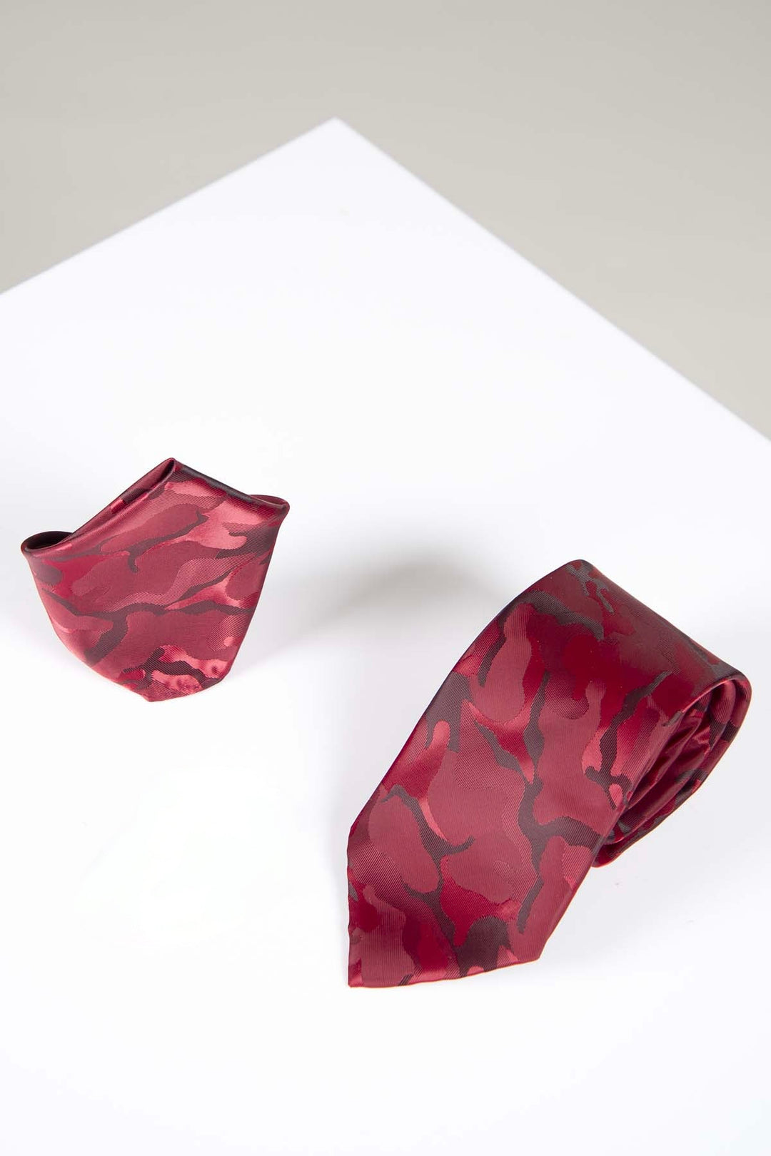The Accessory TS ARMY Wine Camouflage Tie and Pocket Square Set features a red camo print, stylishly displayed on a white surface with a light gray background—ideal for adding flair to your formal attire.