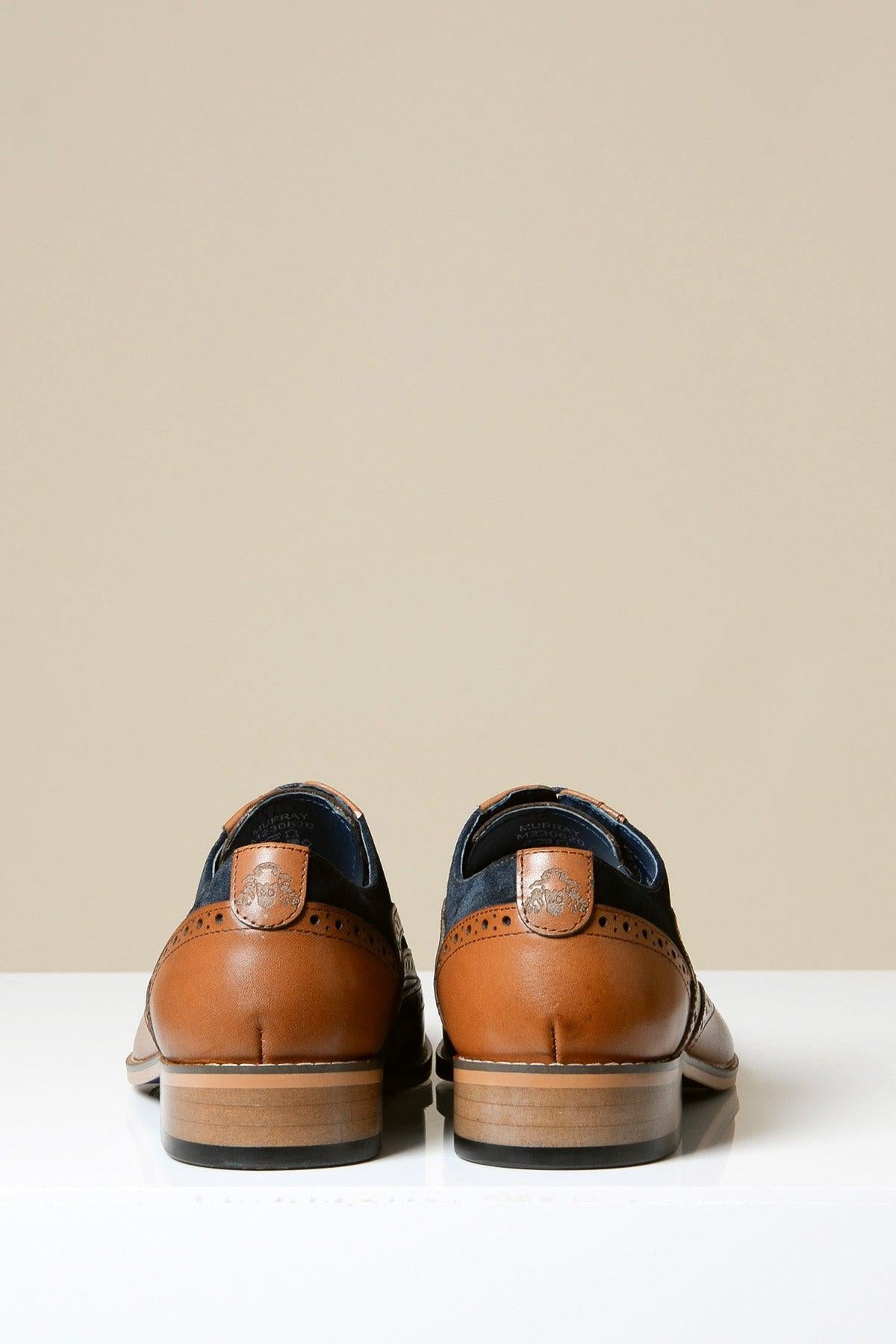 A pair of Marc Darcy MURRAY Contrast Tan Leather Suede Brogue Shoes with decorative perforations is displayed side by side on a white surface, viewed from the back against a beige background.