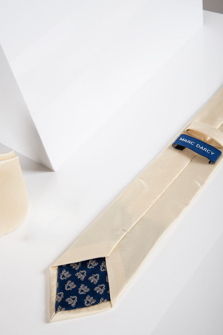 The TB17 - Birdseye Tie and Pocket Square Set in Yellow by Accessory is shown on a white geometric surface, featuring a coordinating tie and pocket square.