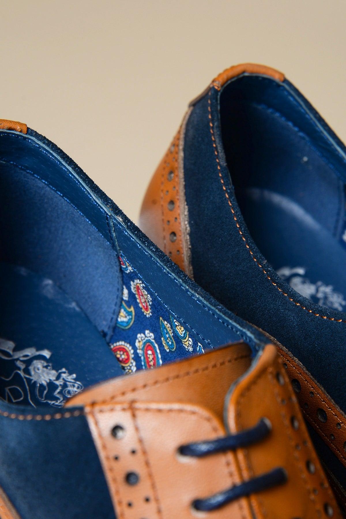 Close-up of Marc Darcy MURRAY shoes, featuring contrast tan leather and navy blue suede with brogue details and detailed stitching. The inner lining displays a colorful paisley pattern in blue, red, and yellow.
