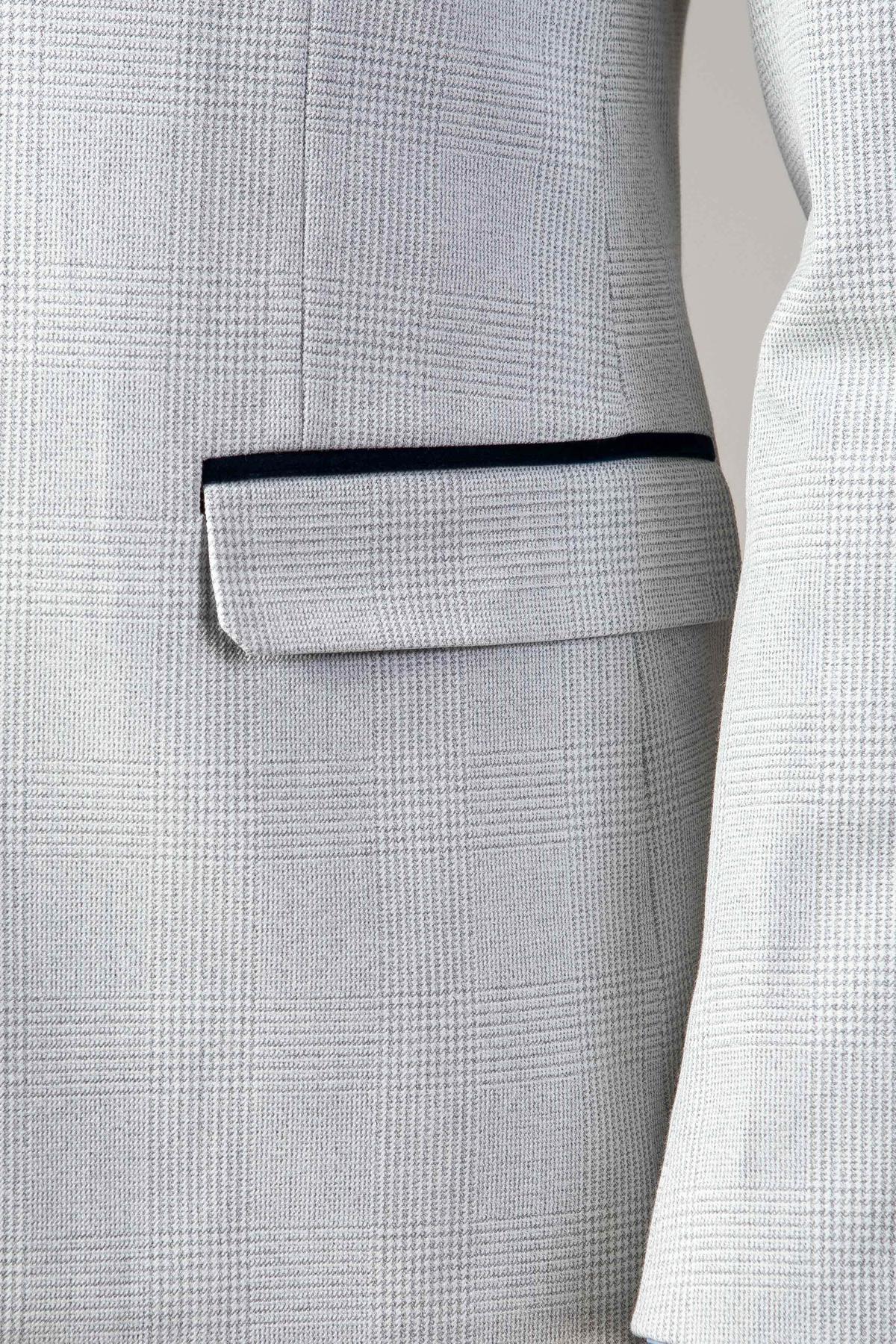 Close-up of a light grey plaid blazer with black trim pocket from Marc Darcy’s WBA Collection - BROMLEY Stone Suit, inspired by men’s slim fit formalwear.