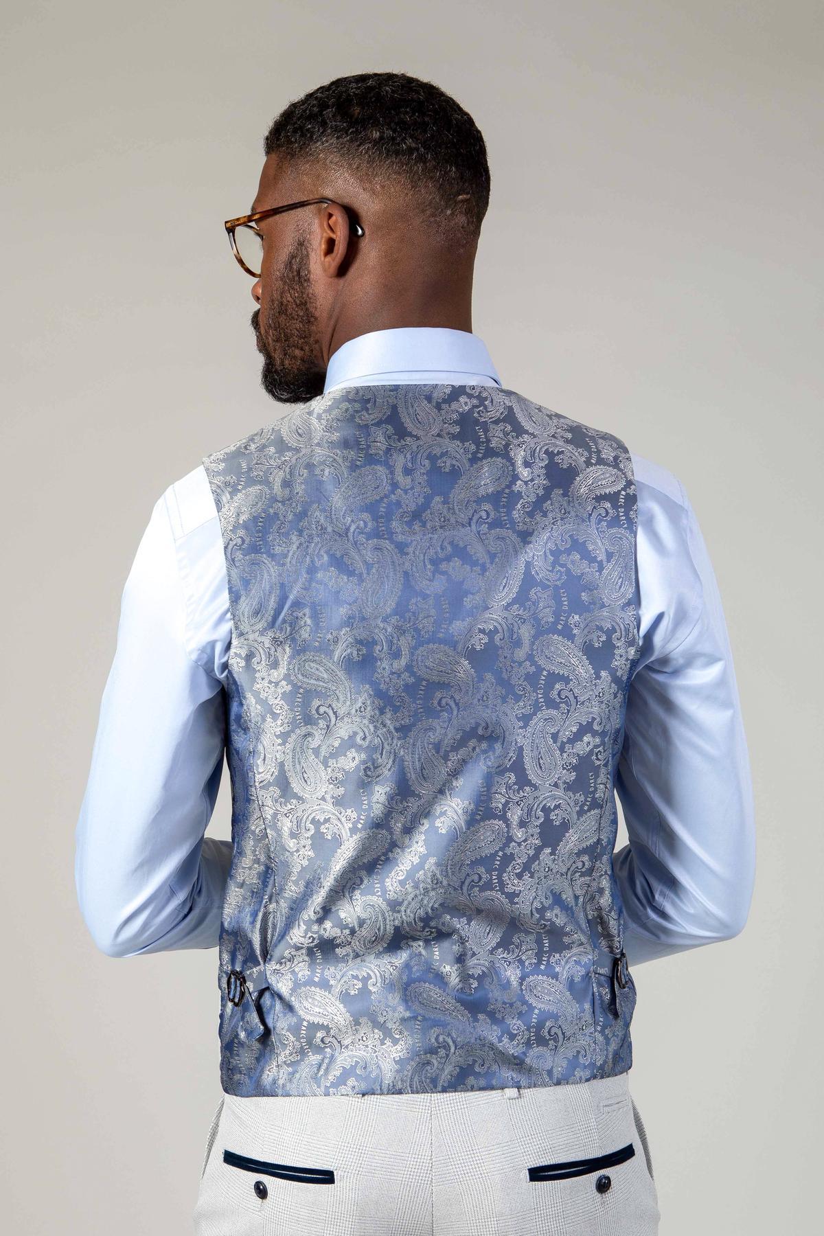 Back view of a Black man wearing the Marc Darcy BROMLEY Stone Suit from The WBA Collection, featuring a light blue dress shirt and a silver paisley vest as part of this sharp three-piece ensemble.