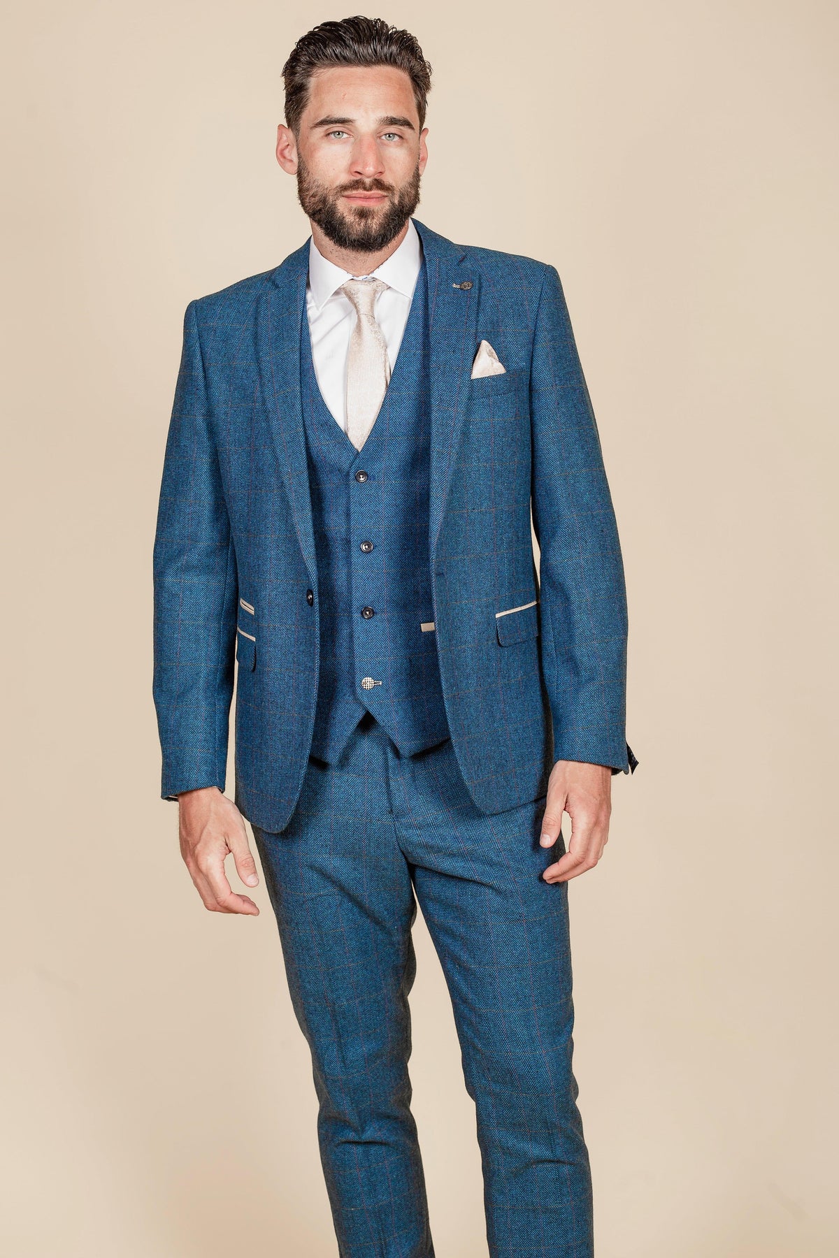 Ashley Young wears the marcdarcy Everton Collection DION Blue Tweed Check Suit with a white shirt, cream tie, and pocket square, standing against a plain beige background.