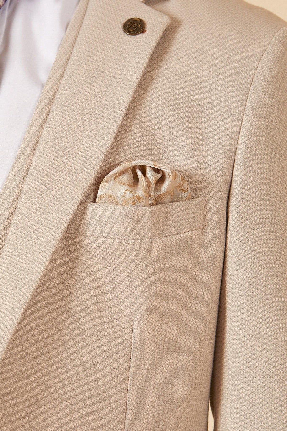 A close-up of the Marc Darcy Leicester City F.C. Collection HM5 Stone Suit with Kelvin Black Waistcoat, as worn by Mads Hermansen. Features a gold lapel pin, patterned silk pocket square, and crisp white shirt underneath.