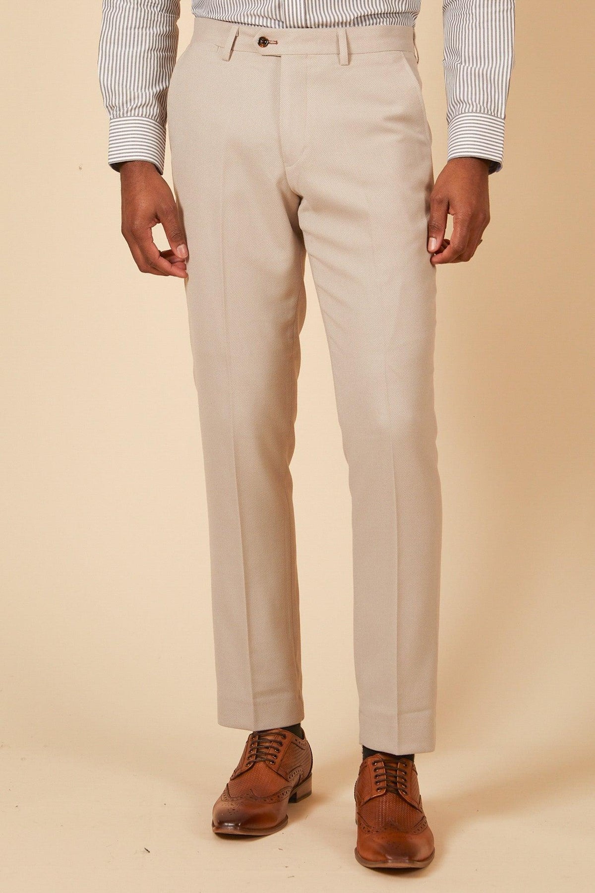 A man wears the Marc Darcy Leicester City F.C. HM5 Stone Suit with Kelvin Black Waistcoat, as worn by Mads Hermansen, for a look as sharp as classic dress pants and wingtip shoes.