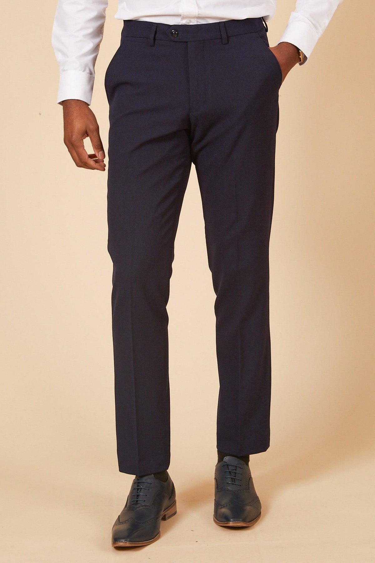A person wearing Marc Darcy’s The WHU Collection - BROMLEY Navy Check Three Piece Suit (as worn by Lukasz Fabianski) stands against a beige background, showing only the lower body.