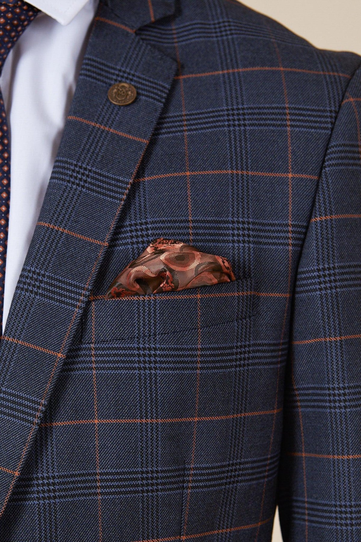Close-up of a man in the marcdarcy WBA Collection - JENSON Marine Navy Check Suit as worn by John Swift, featuring a slim fit jacket with subtle checks, white shirt, navy patterned tie, and brown pocket square for added sophistication.