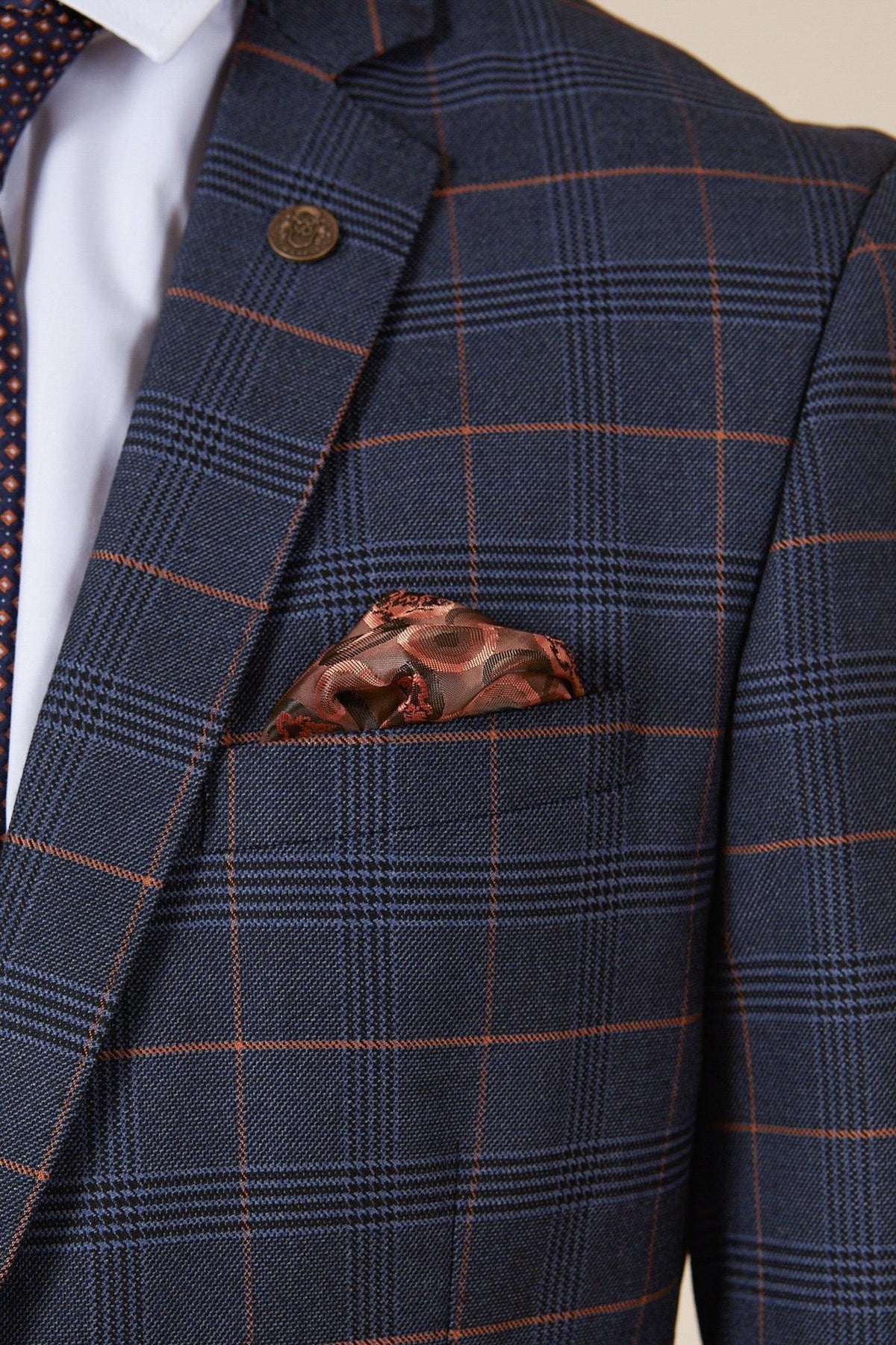 A man wearing The WBA Collection - Jenson Marine Suit With Kelvin Tan Waistcoat by marcdarcy, as worn by John Swift, styled with a white dress shirt, navy polka dot tie, and a brown patterned pocket square.