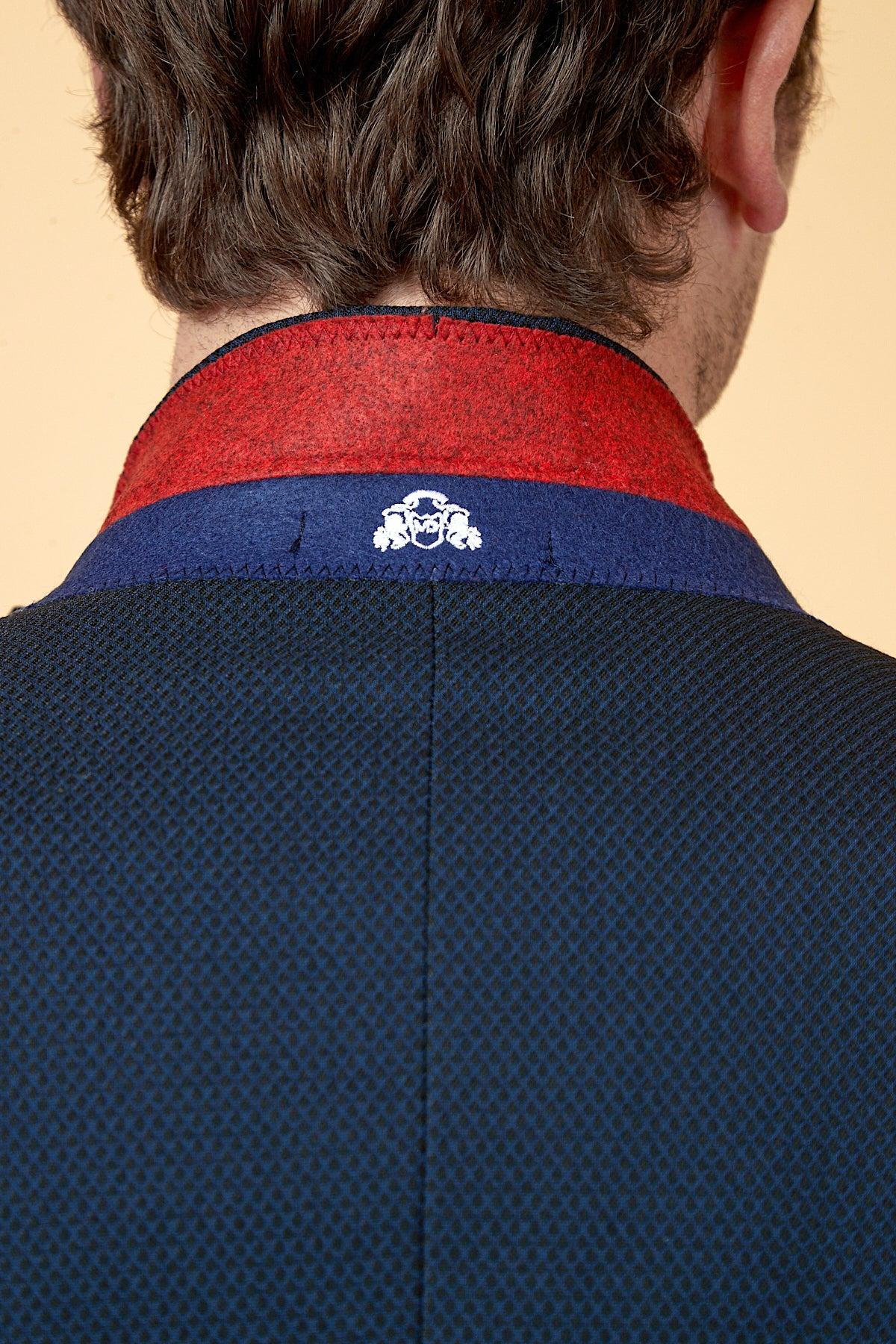 Close-up of the back of marcdarcy's The WHU Collection - MAX Navy Three Piece Suit as worn by Max Kilman, showing a patterned collar with red and blue lining and a white embroidered emblem.