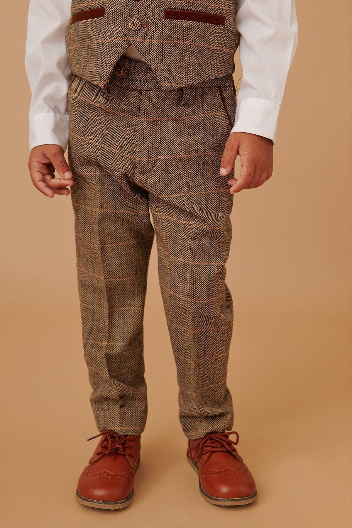 A young child wears the marcdarcy TED Childrens Tan Tweed Check Three Piece Suit with a white dress shirt and brown leather shoes, standing against a beige background. The childs face is not visible.