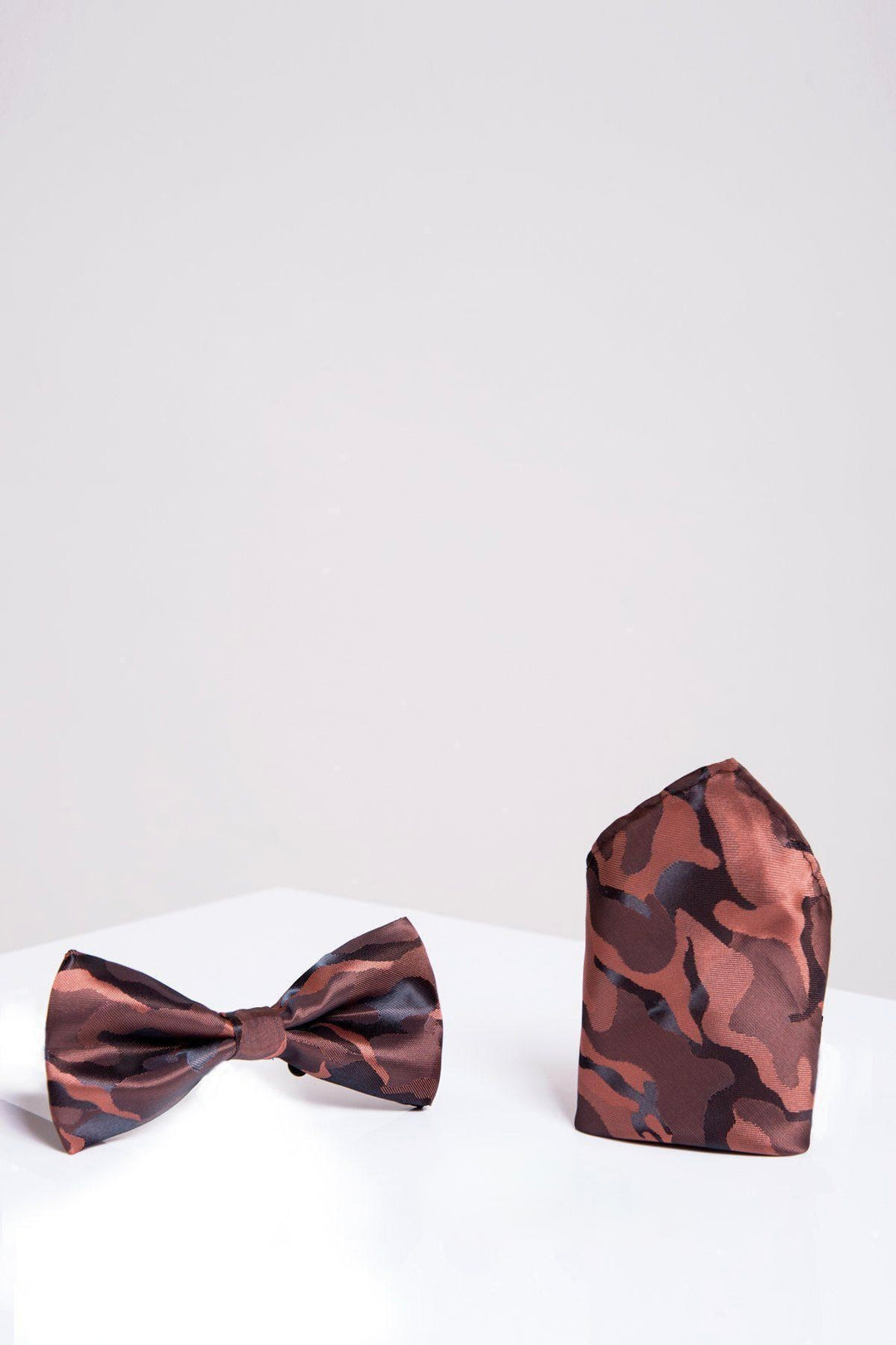 The Accessory BT ARMY - Copper Camouflage Bow Tie and Pocket Square Set, featuring a pre-tied bow tie in brown and black army print with a matching pocket square, is displayed on a white surface against a plain light background.