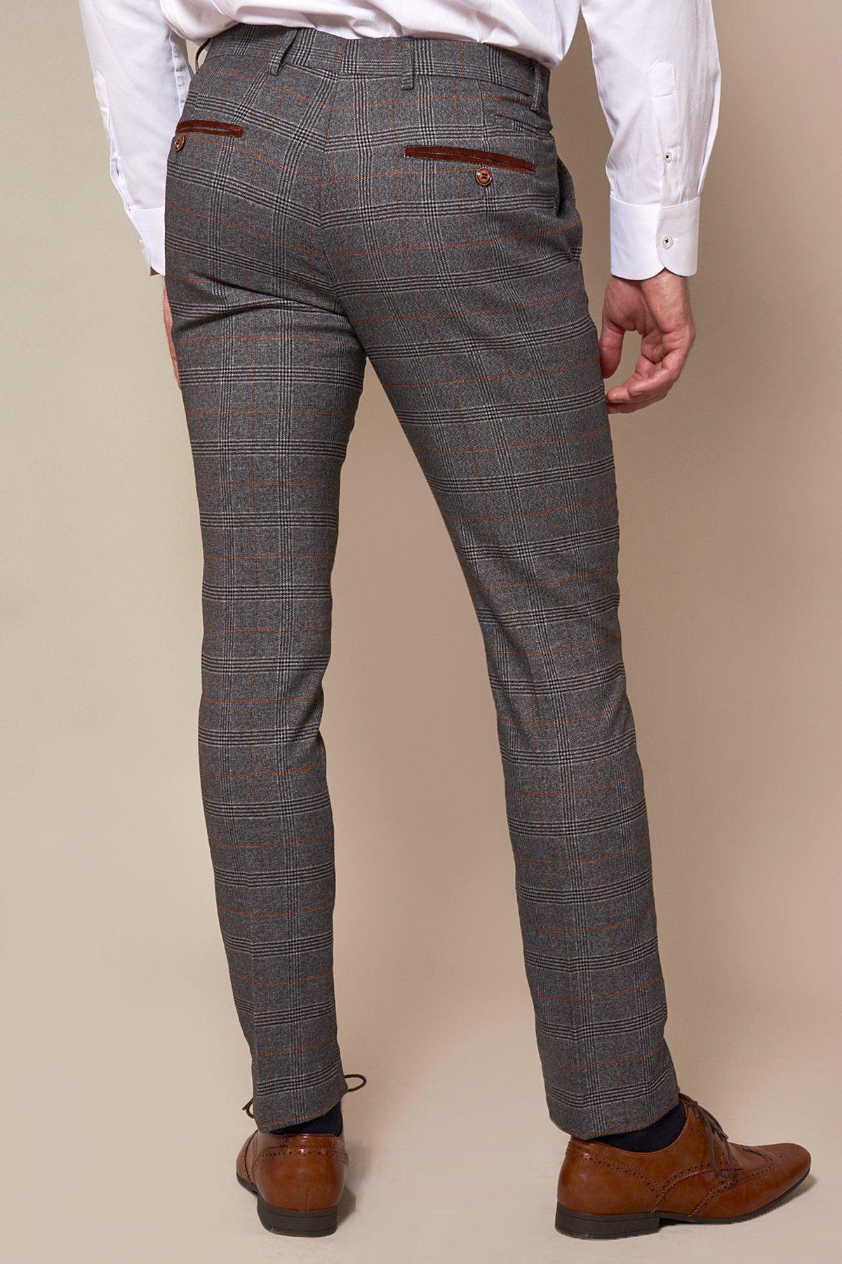A person wearing marcdarcy JENSON Skinny Fit Grey Check Trousers, a white dress shirt, and brown dress shoes stands with their back to the camera against a plain beige background.