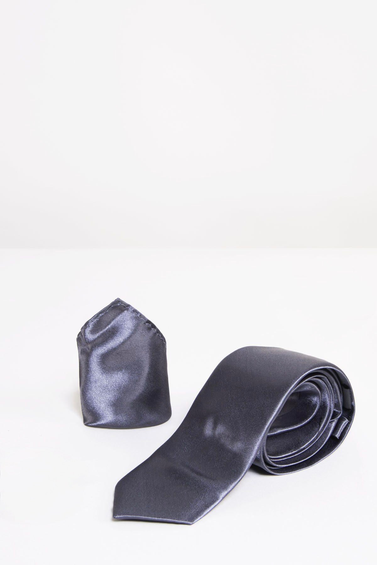 The Accessory ST - Satin Tie and Pocket Square Set in Charcoal features a neatly folded pocket square standing upright beside a rolled satin tie, both displayed on a white surface against a plain white background.