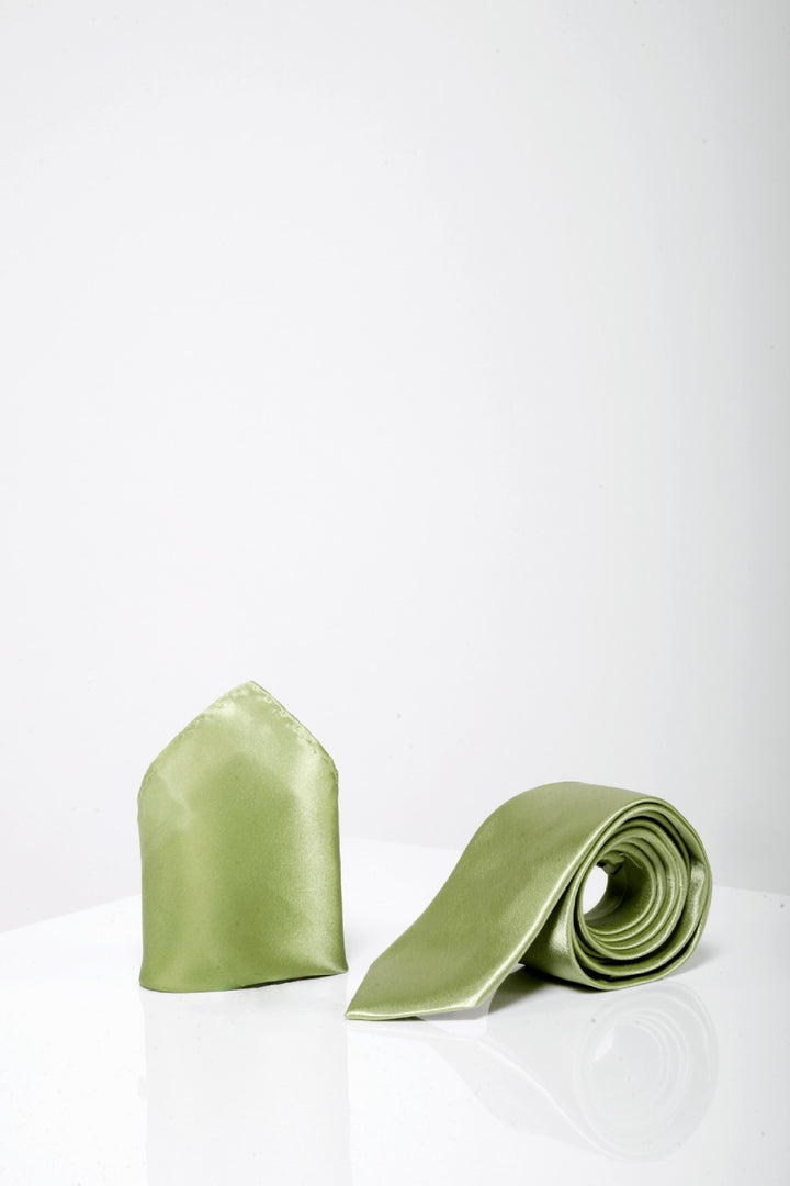 The Accessory ST - Satin Tie and Pocket Square Set In Green stands upright on a glossy white surface, displayed against a plain white background.