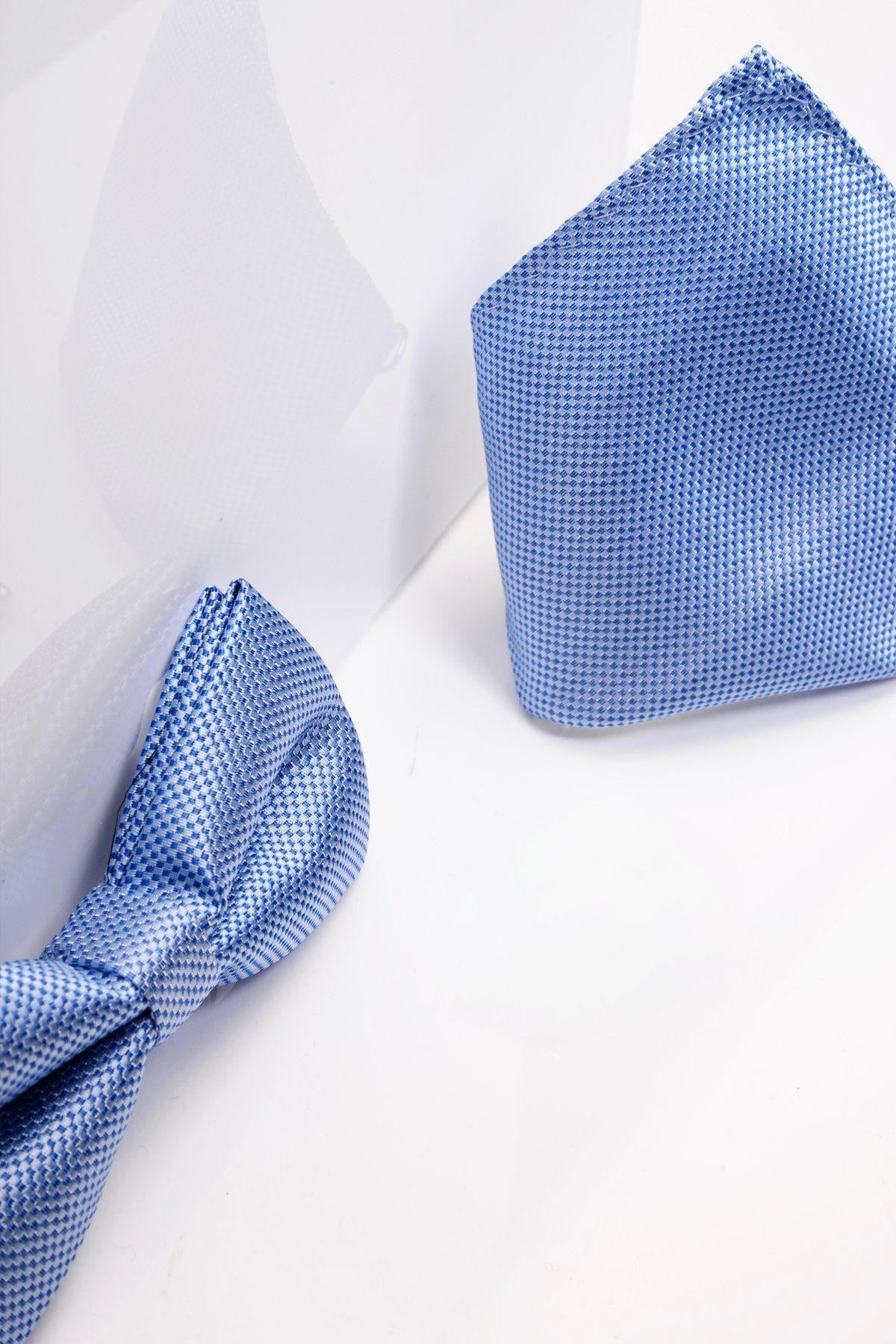 The Accessory TB17 Birdseye Print Bow Tie and Pocket Square Set in Blue is displayed on a white surface with soft shadows, presenting this pre-tied set as a refined wedding accessory.