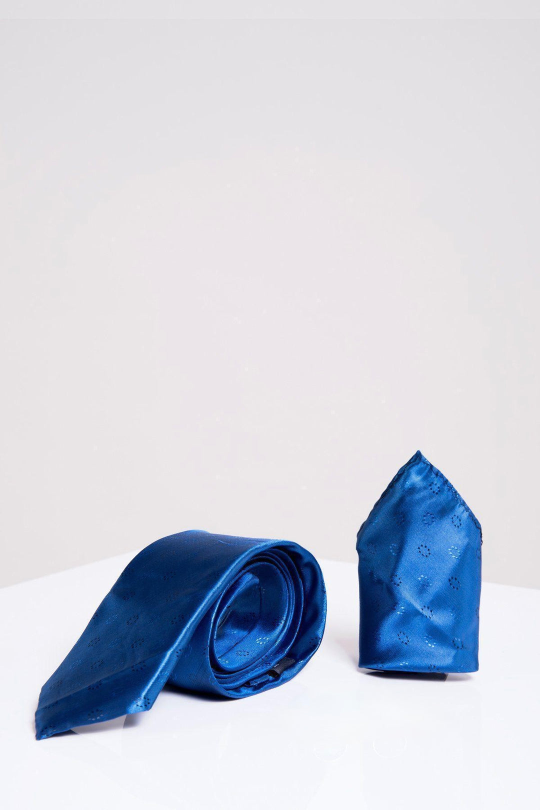 The Accessory TS CIRCLE Blue Circle Tie and Pocket Square Set, with its sleek satin finish, is styled partially rolled next to the upright pocket square—ideal for adding elegance to your tux on a clean white background.