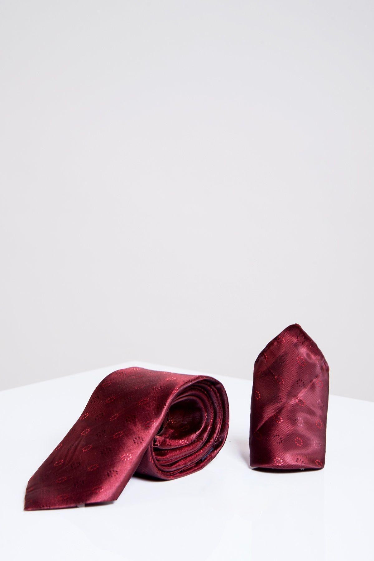 The Accessory TS CIRCLE Wine Circle Tie and Pocket Square Set is shown on a glossy white surface, with the maroon tie's subtle circle pattern matching the neatly folded pocket square, set against a plain light grey background.