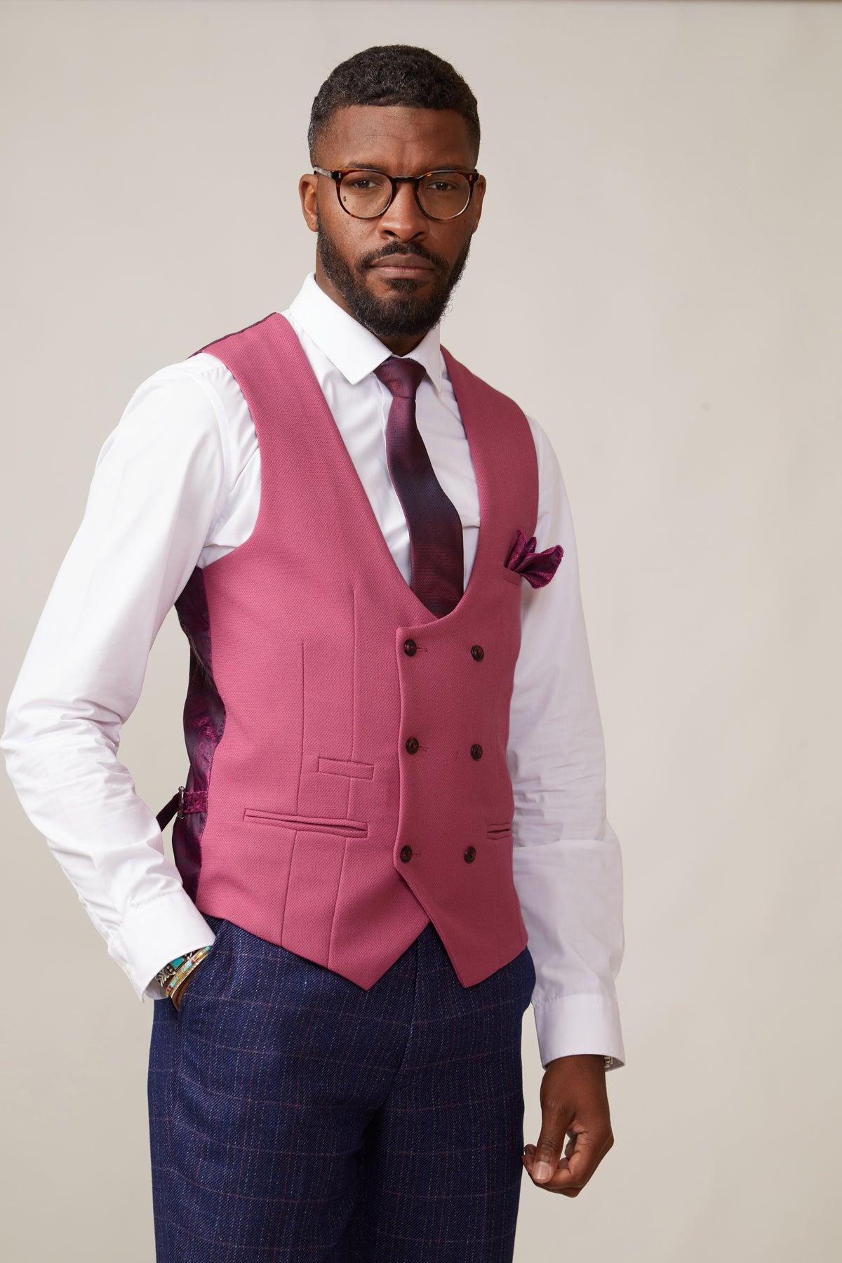 A man in a white shirt, dark purple tie, marcdarcy's KELVIN - Berry Double Breasted Waistcoat with matching pocket square and blue plaid trousers stands against a plain light background.