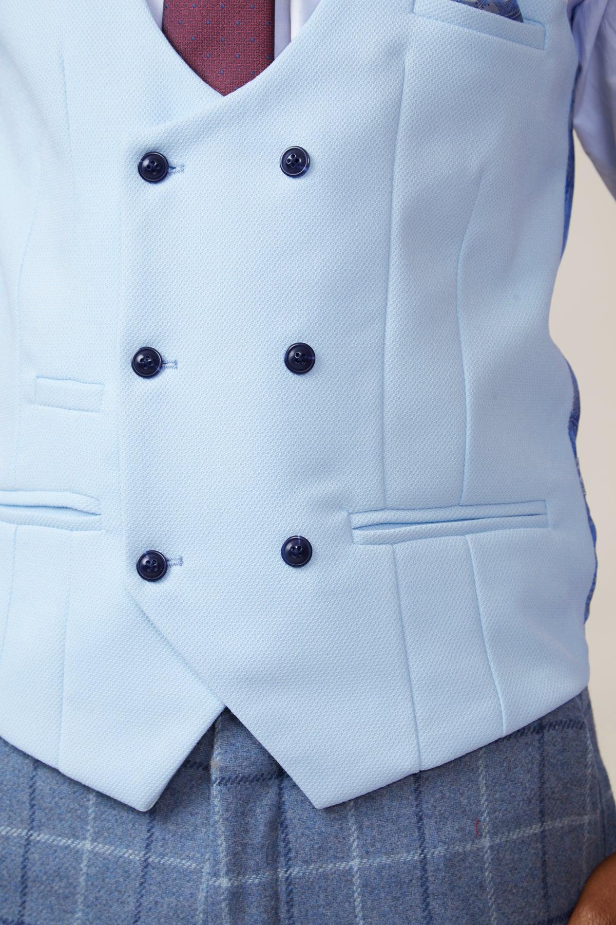 Close-up of the marcdarcy KELVIN sky blue double-breasted waistcoat with navy buttons, styled over a patterned tie and blue plaid suit.