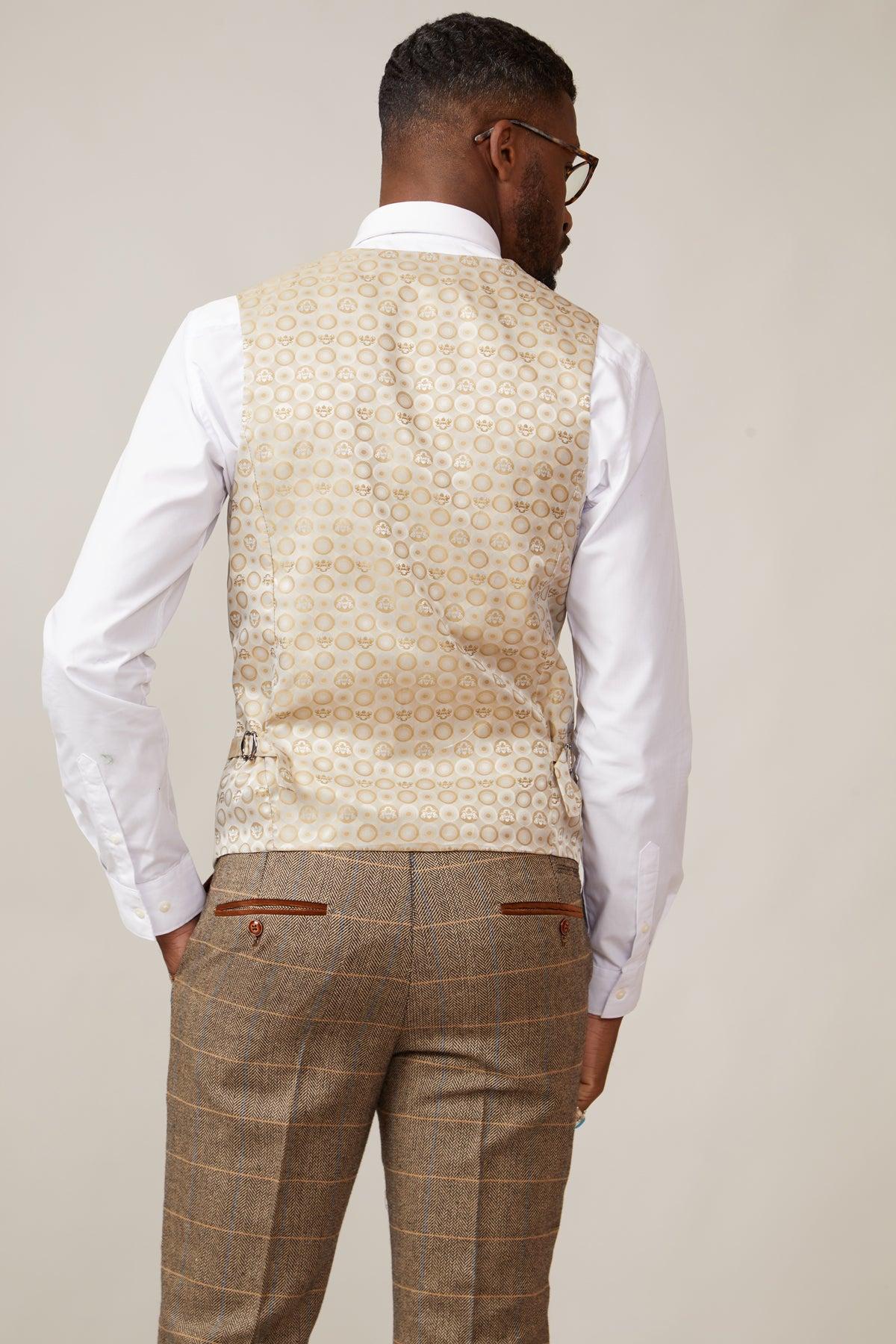 A man seen from the back wears a marcdarcy KELVIN cream double breasted waistcoat over a white shirt and brown plaid trousers, showcasing classic British tailoring.