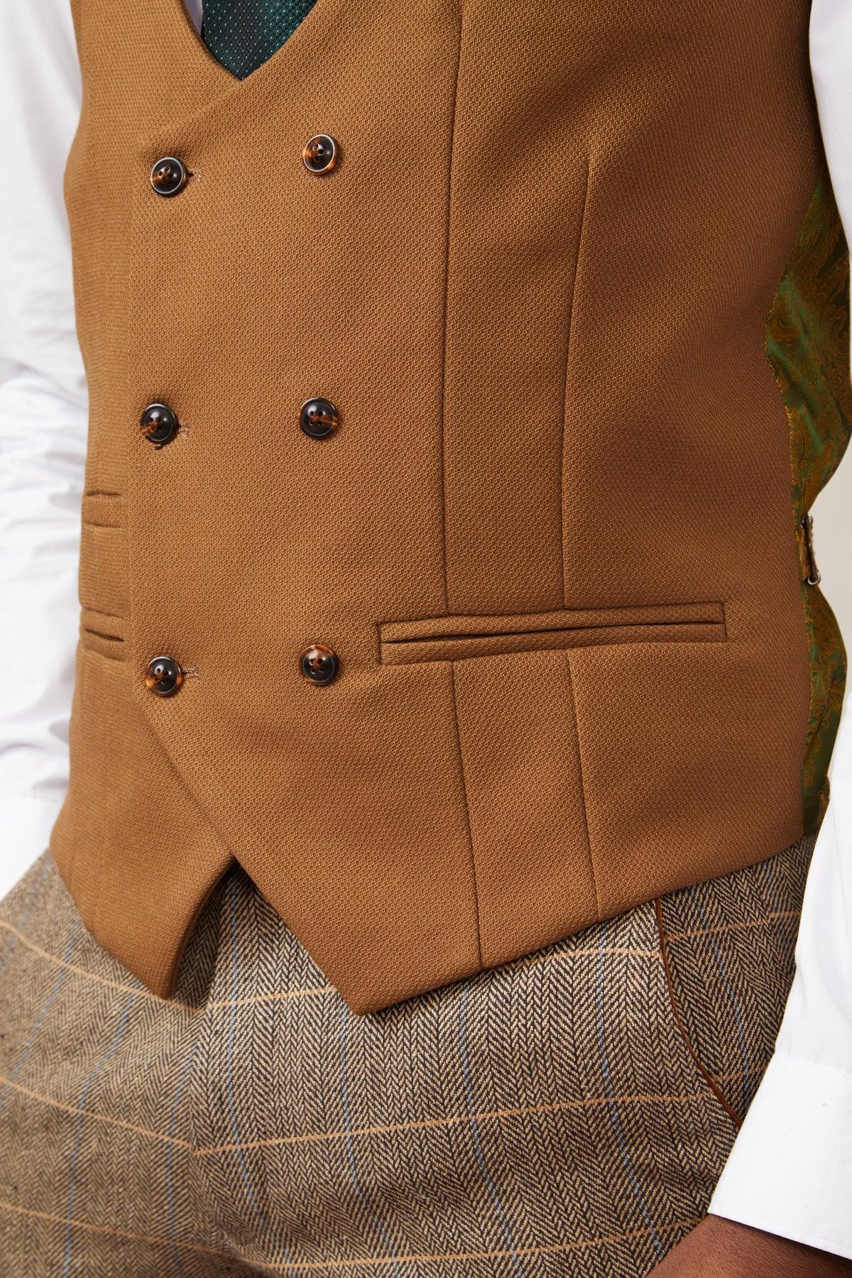 A close-up of a person wearing the marcdarcy KELVIN Tan Double Breasted Waistcoat over a white shirt, styled with brown tweed trousers and a green patterned tie for a refined slim-fit look.