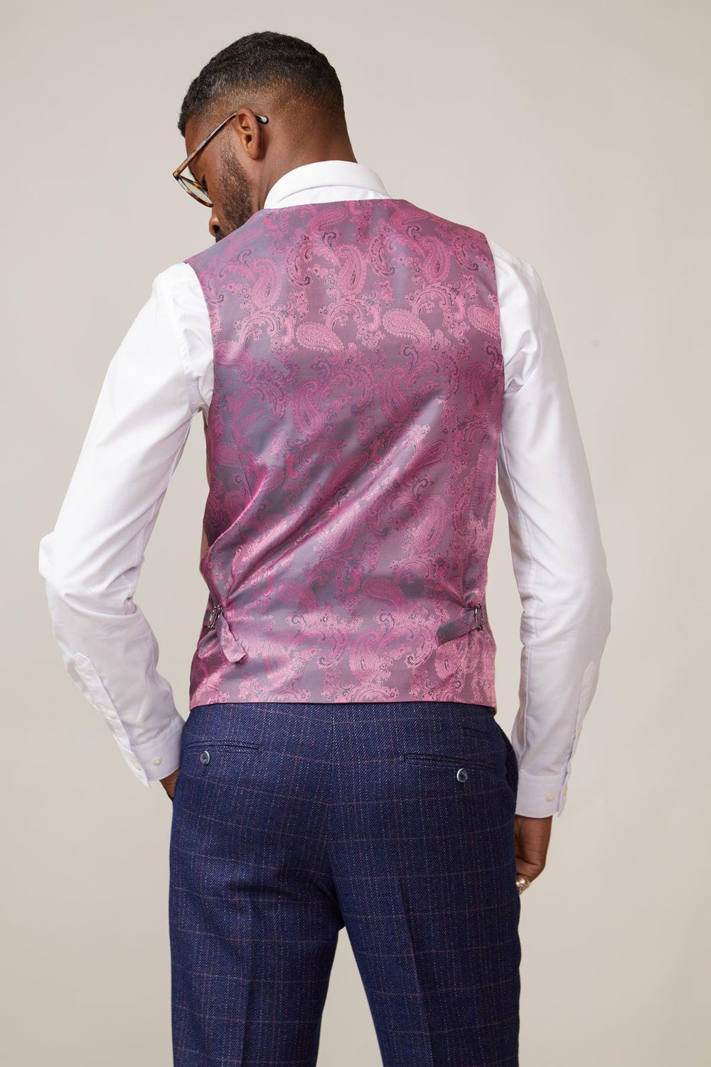 Back view of a man wearing a white shirt, blue plaid trousers, and the marcdarcy KELVIN pink double breasted waistcoat.