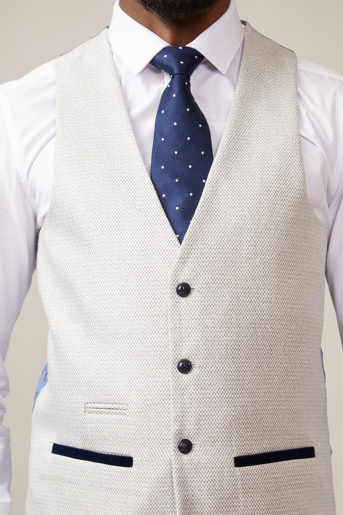 A man wearing a slim fit penny collar shirt, a patterned blue tie, and the marcdarcy RONALD Stone Single Breasted Waistcoat.