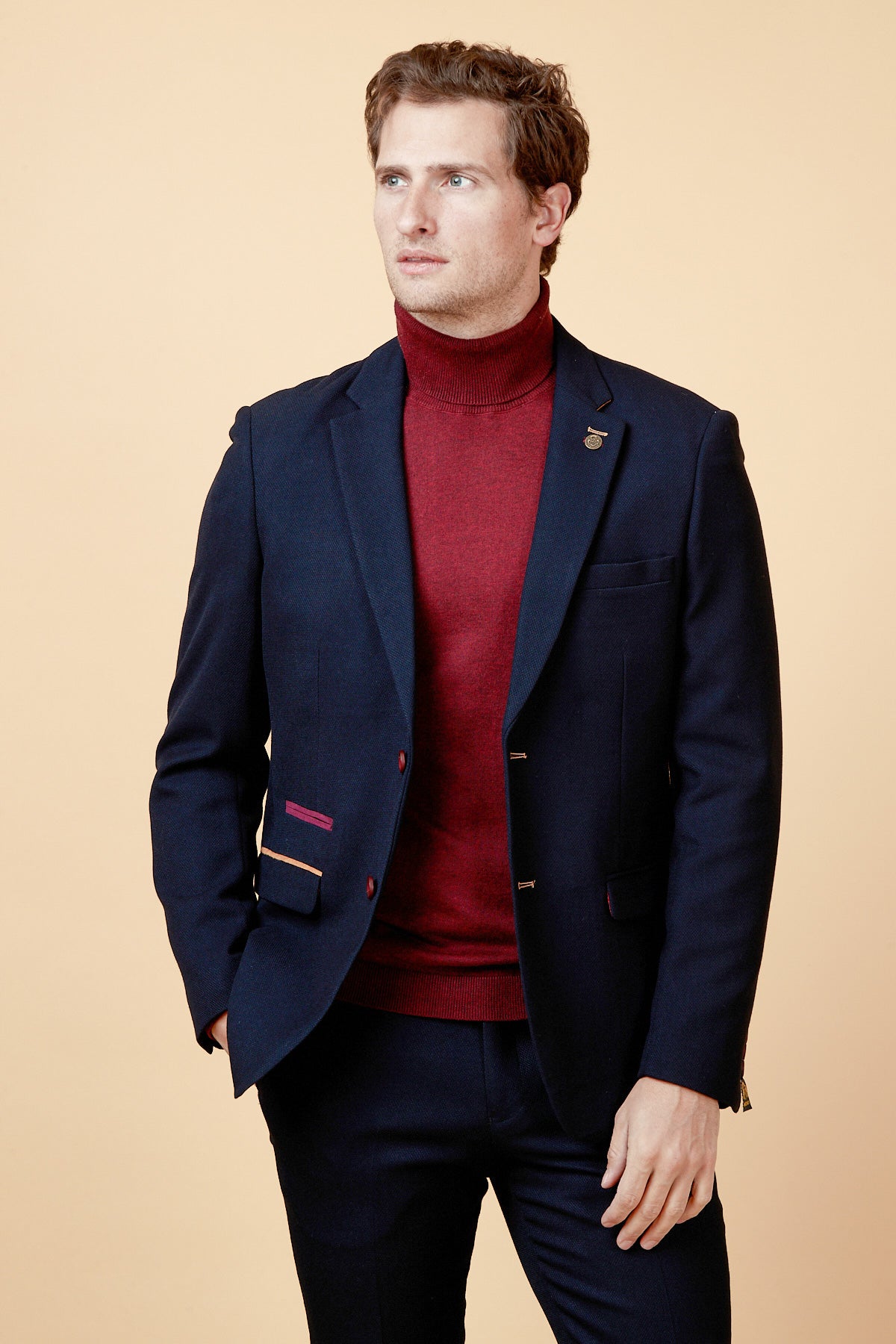 A man models the marcdarcy JD4 - Navy Contrast Trim Blazer over a maroon turtleneck against a light beige backdrop, looking slightly left with a neutral expression—a stylish choice for workwear or as a wedding guest.