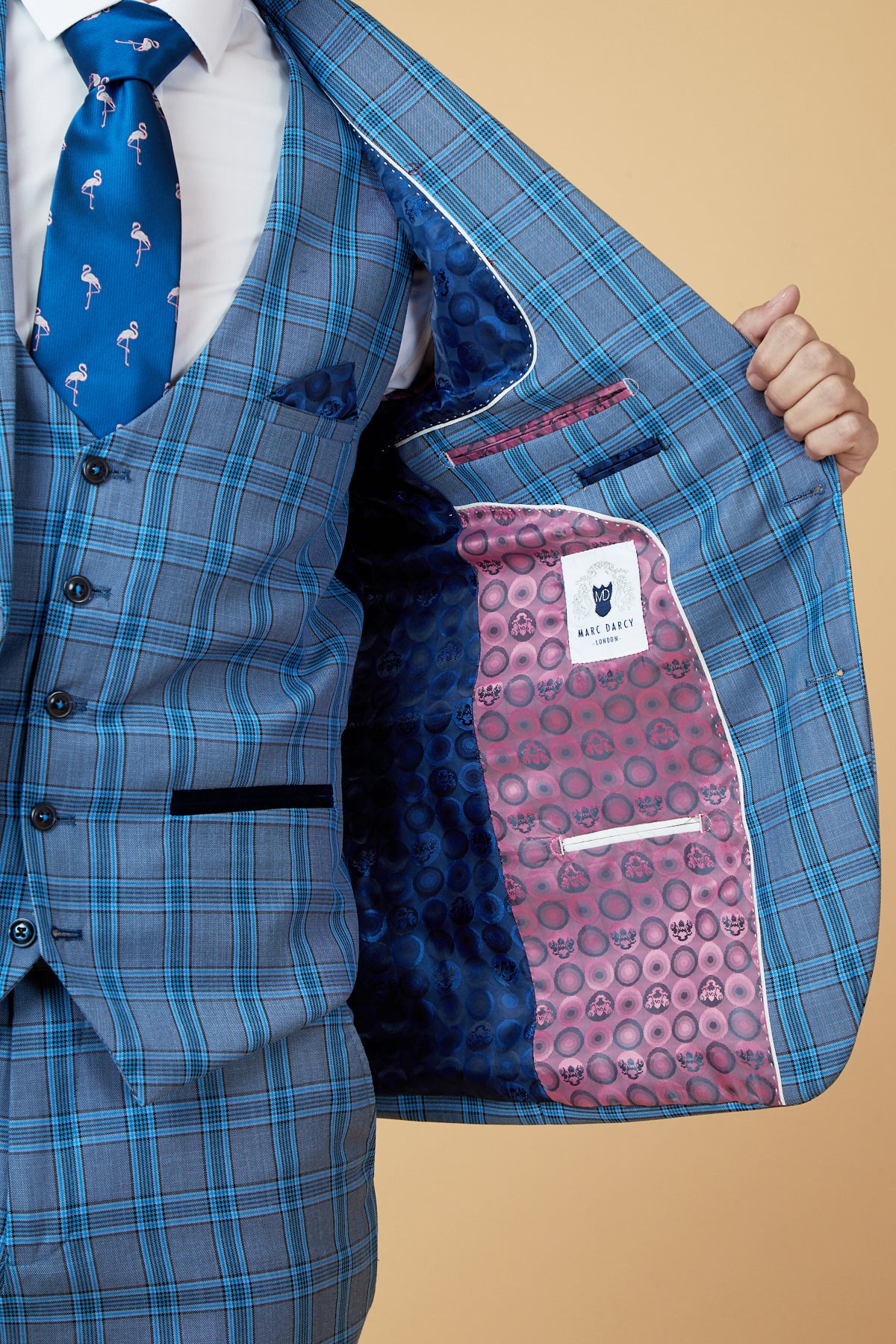 Close-up of a man wearing the Marc Darcy JOSE - Sky Blue Check Blazer, showcasing its tailored fit, bold patterned lining, and a flamingo tie accent.