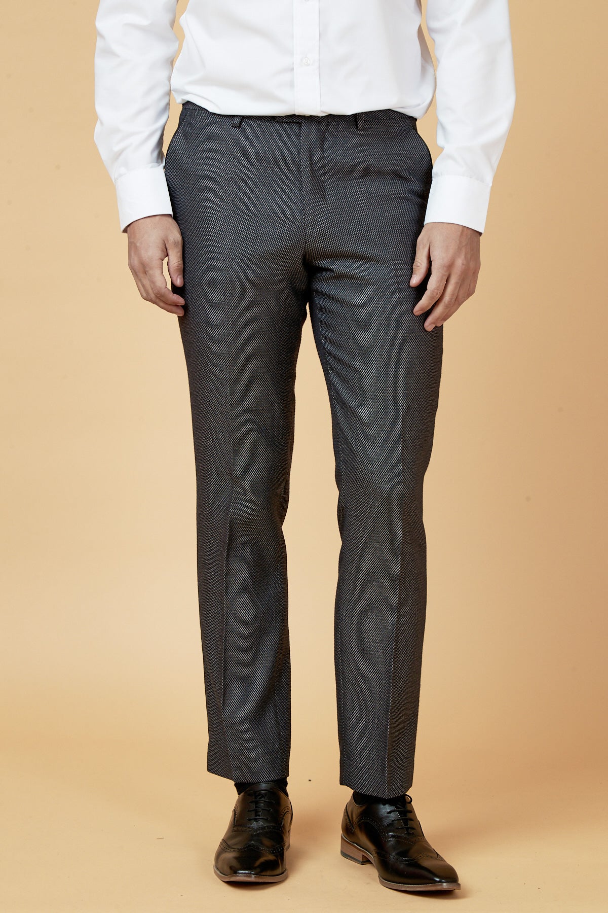 A person models the marcdarcy SPENCER - Charcoal Grey Tux Lapel Three Piece Suit, featuring a slim fit, against a plain beige background. The white shirt and black dress shoes complete the look; the person's head is not visible.